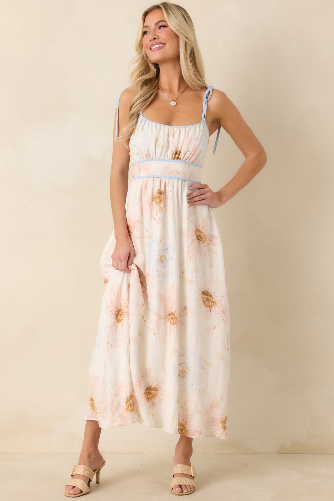 Feminine ivory midi dress showcasing watercolor florals, adjustable straps, and an effortless flowing design.