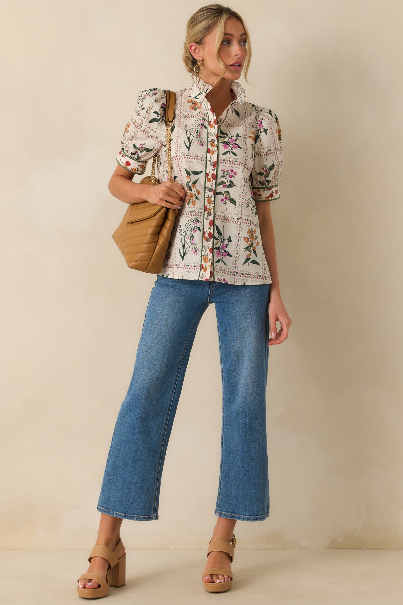 A front view of the ivory floral top highlighting the pleated ruffle collar and puff sleeves.