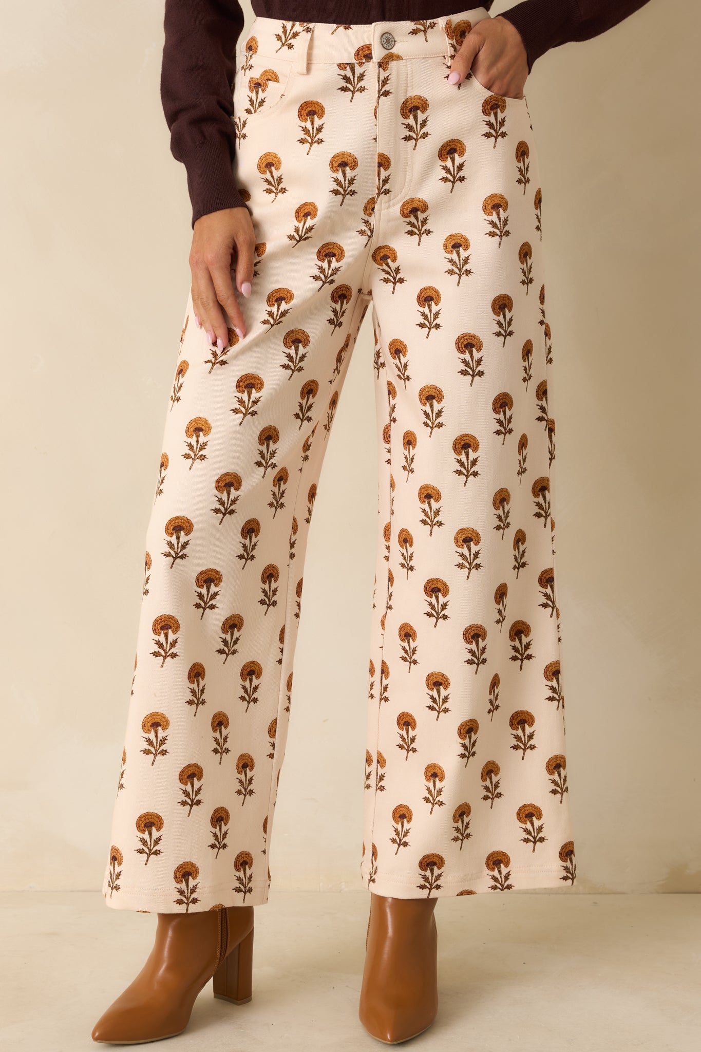 Ivory pants focused on the front zipper closure, side pockets, and printed fabric texture.