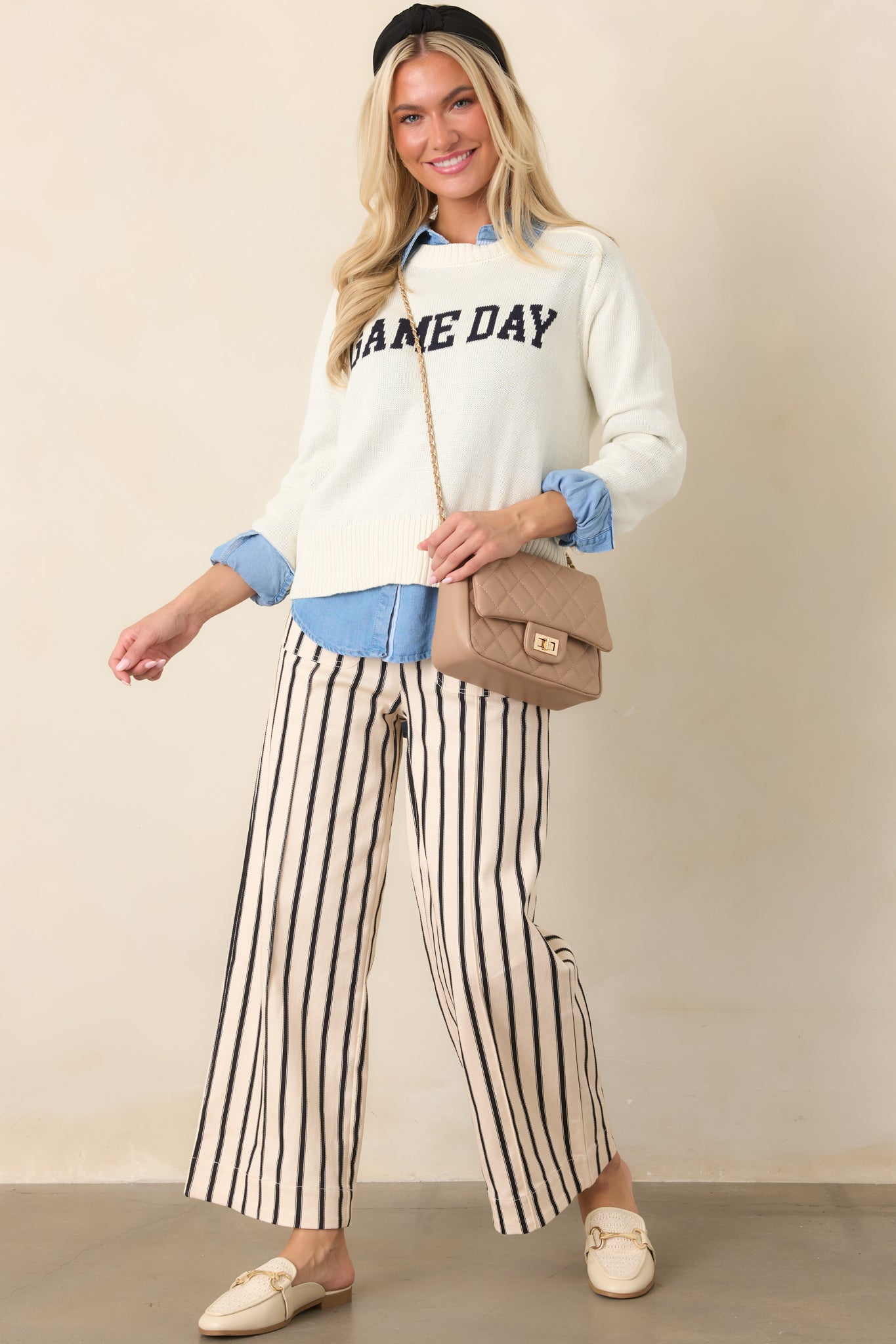 Ivory cotton knit top with a relaxed, slightly cropped fit, crew neckline, long sleeves, ribbed trim, and bold navy “GAME DAY” lettering.
