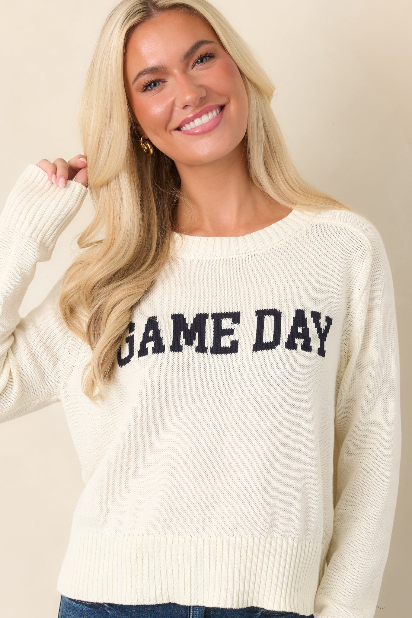 Front detail of the ivory knit top highlighting the bold navy “GAME DAY” lettering and softly ribbed crew neckline.