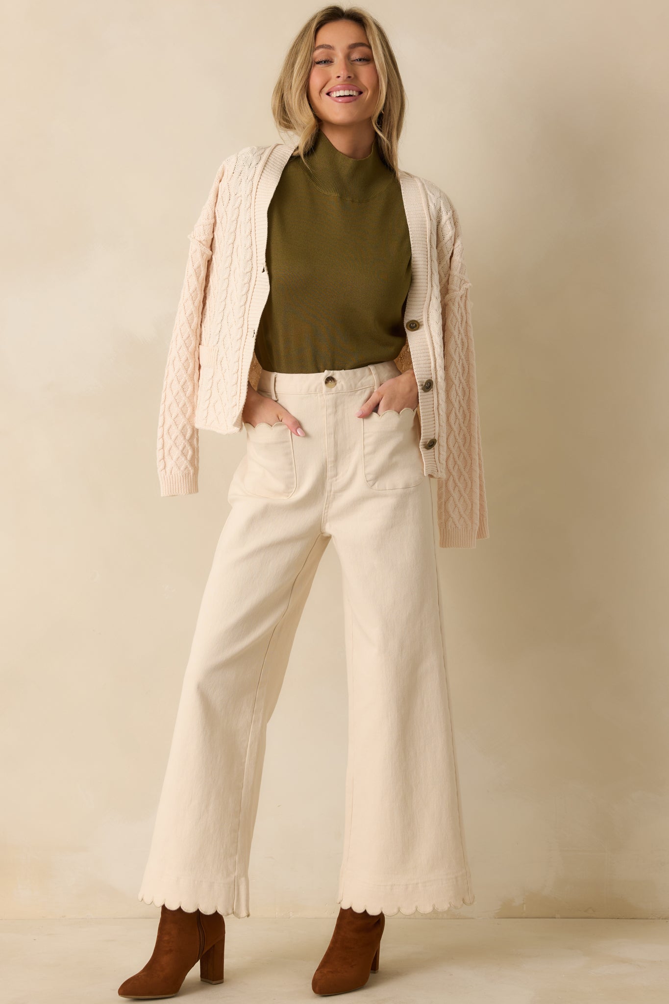 Ivory high-waisted wide-leg pants with front patch pockets, scalloped trim, and structured cotton fabric.