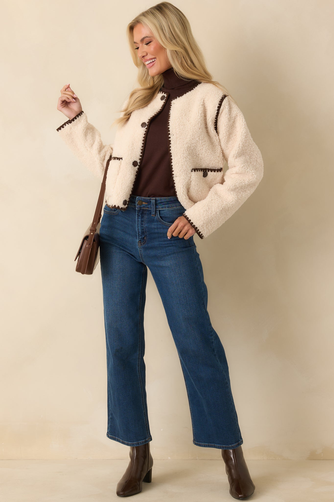 Ivory jacket highlighting the snap-button front and long, easy-draping sleeves.