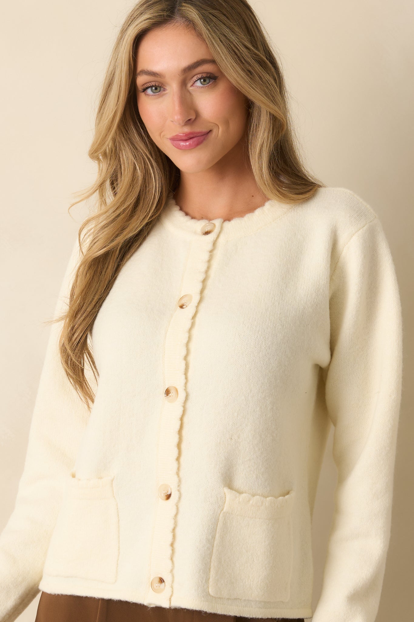 A cropped front view emphasizing the button placket and front pocket stitching on the cardigan.