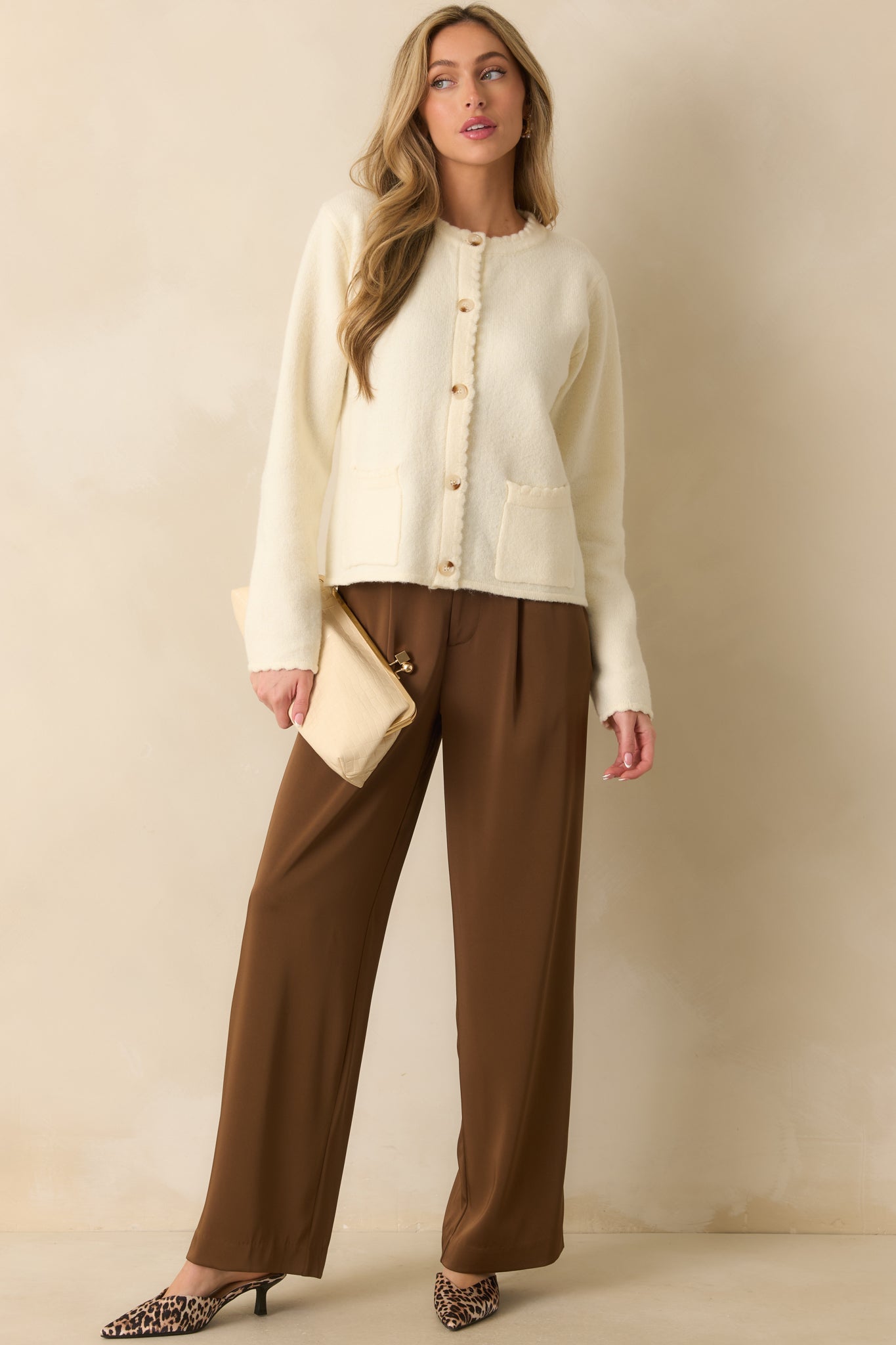 A front view of the ivory cardigan featuring a soft knit fabric and tortoise shell button front closure.