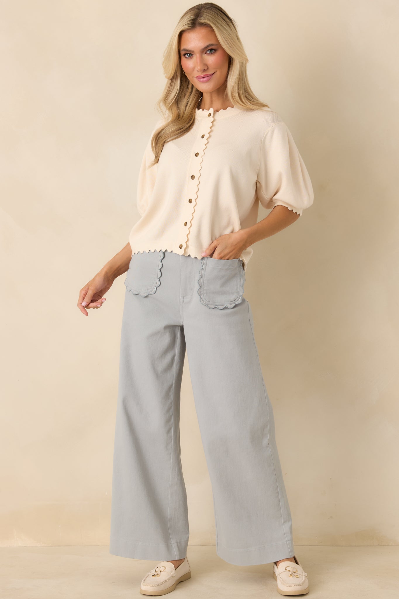 Ivory knit cardigan with a round neckline, button-up front, and a relaxed fit in a lightweight, breathable knit.