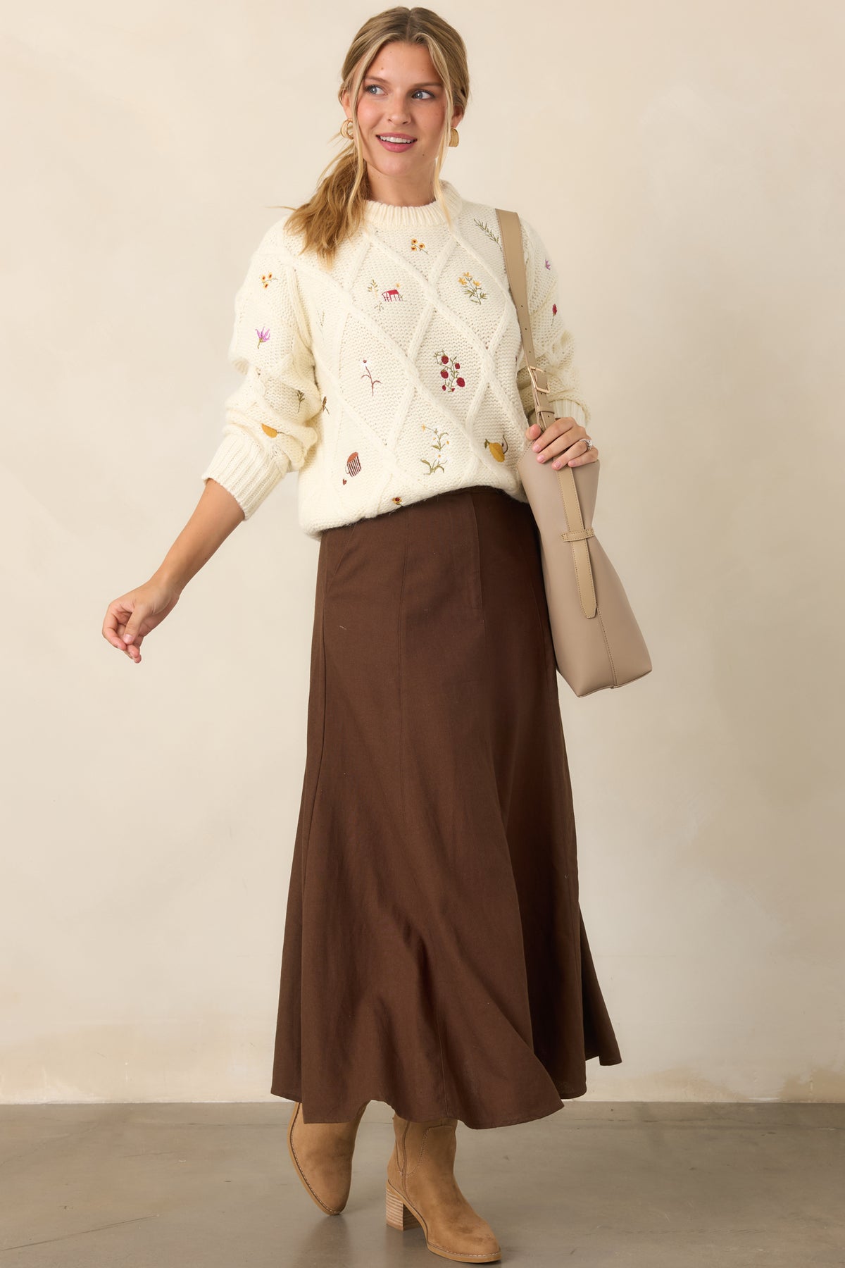 Soft ivory knit top with a raised diamond pattern, colorful garden-inspired embroidery, classic crew neckline, long sleeves, and ribbed trim.