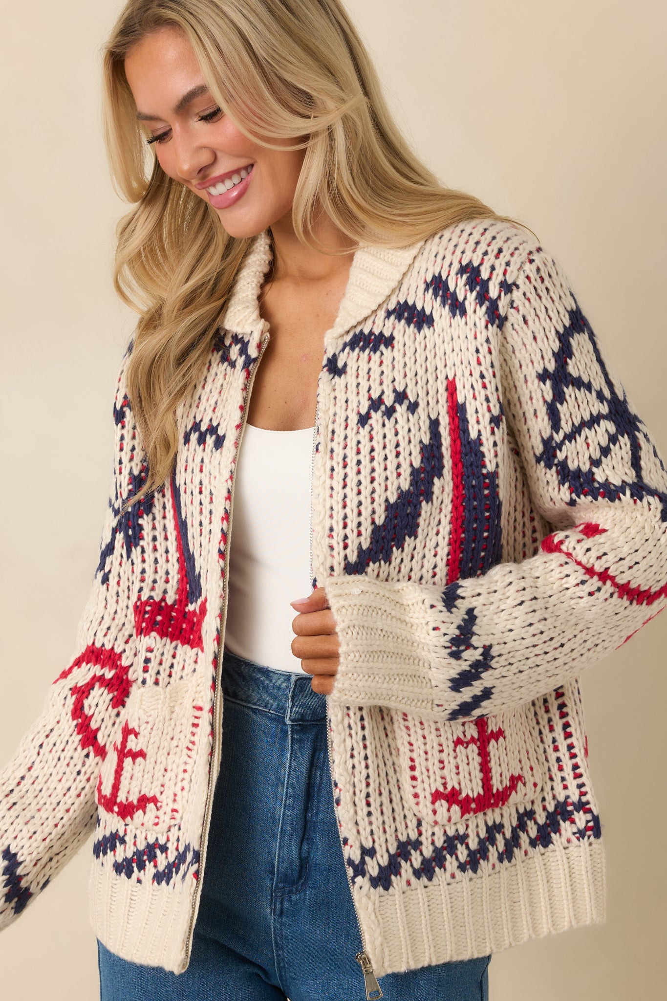 Cropped front view of ivory knit jacket showing collared neckline and full zip closure.