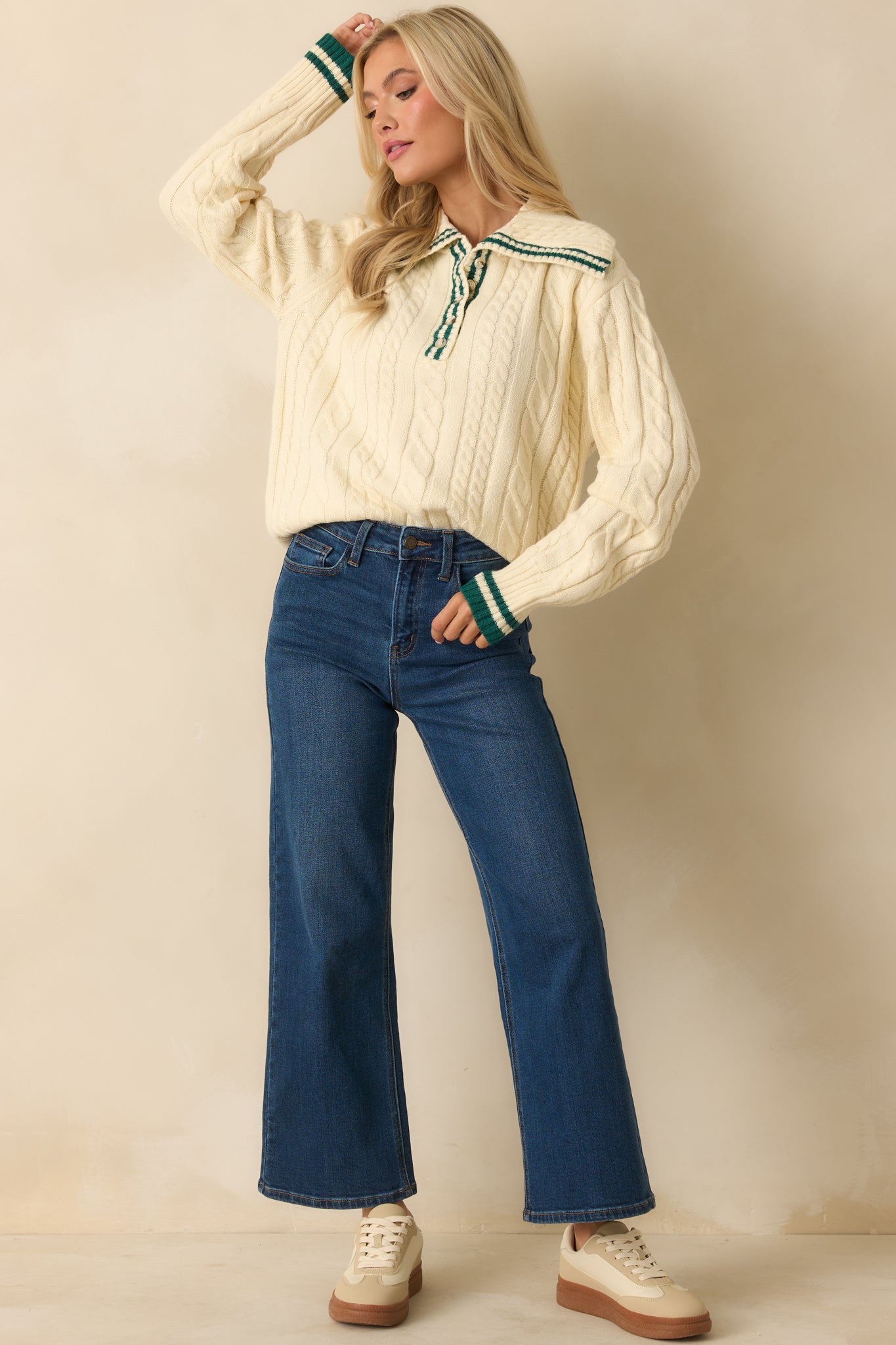 Ivory knit sweater featuring partial button-front closure, ribbed hem and cuffs, and subtle green trim on collar.