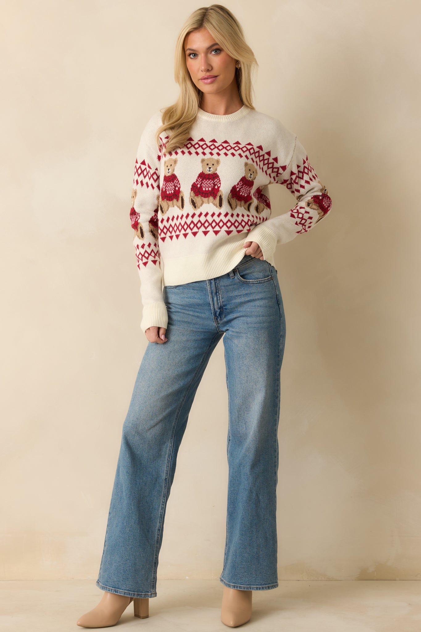 Ivory knit sweater with a classic crew neckline, ribbed trim, and jacquard teddy bear and fair isle patterning in red and neutral tones.