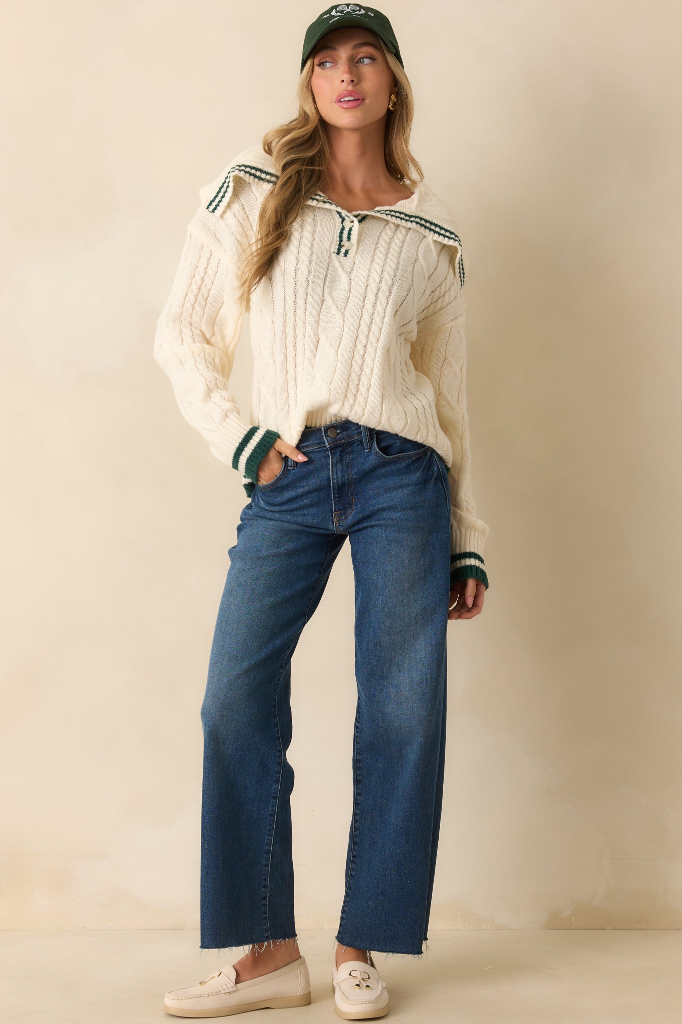 Long-sleeve ivory knit sweater featuring ribbed hems, a relaxed fit, and subtle green striped trim throughout.