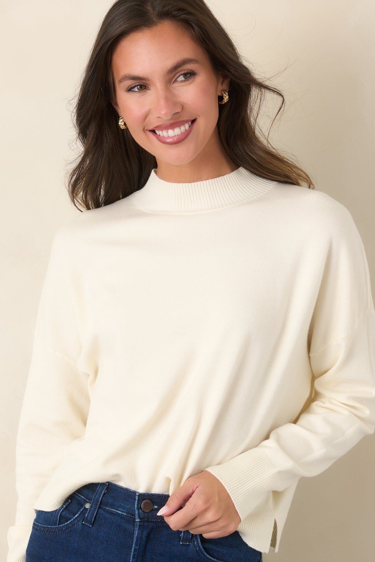 Ivory sweater showcasing its matching ribbed hem and small side slits for a relaxed finish