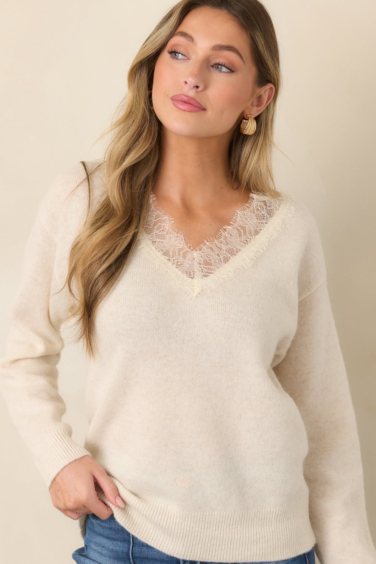 Ivory knit sweater with a softly defined V-neckline and lace detail.