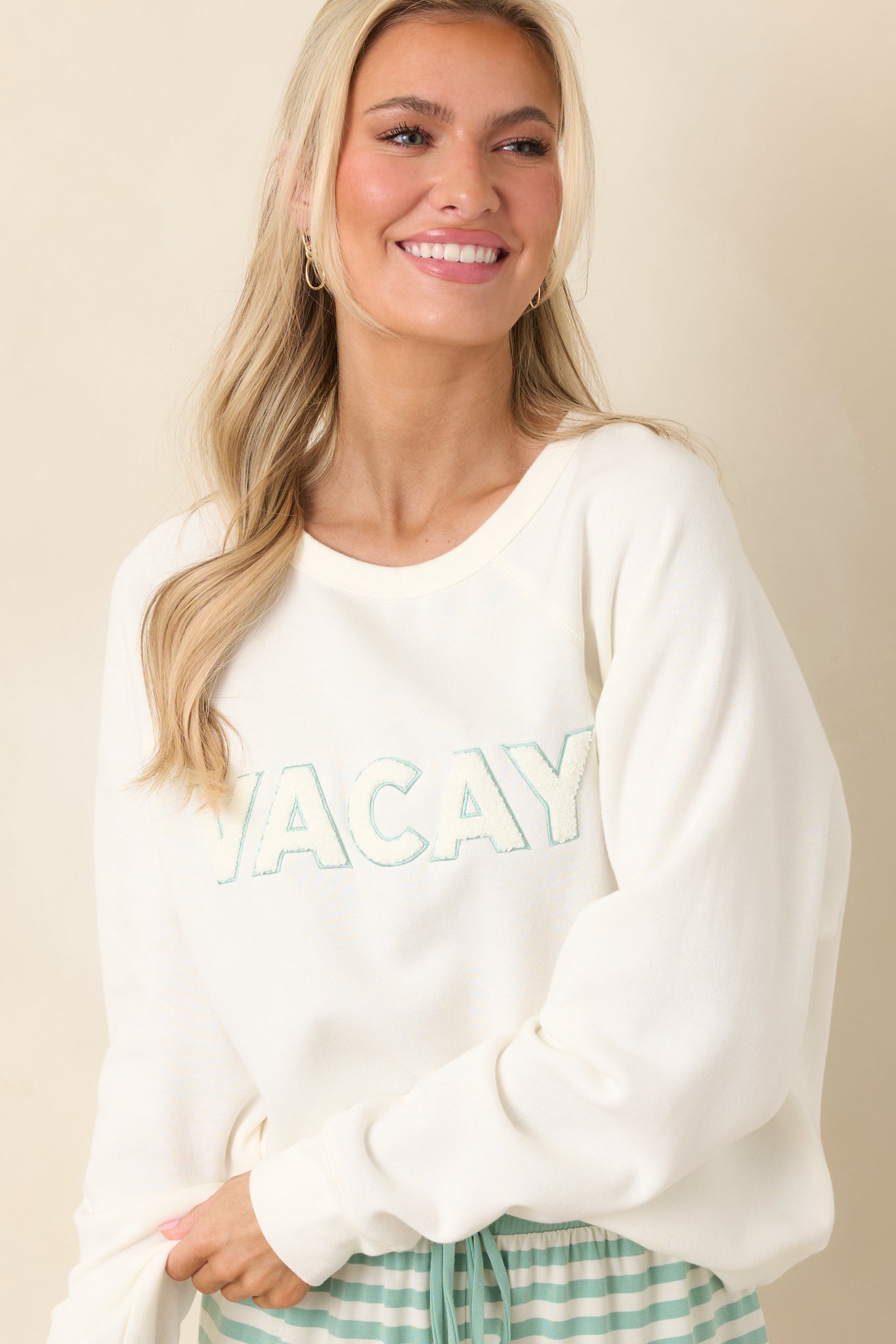 Soft ivory knit texture with raglan sleeve seam and relaxed drape, highlighting the smooth finish and lightweight feel.