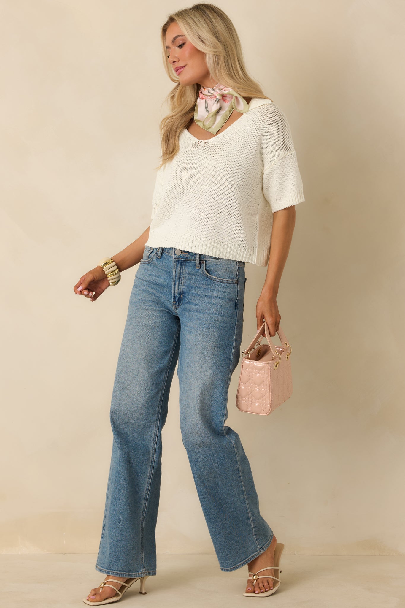 Ivory knit top designed with a classic collar, V-shaped neckline, and airy knit pattern for a fresh, effortless look.