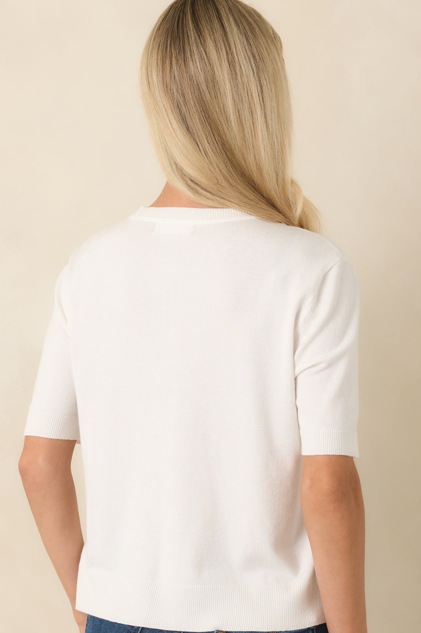 Rear view of the ivory knit top featuring a smooth silhouette and soft knit fabric.