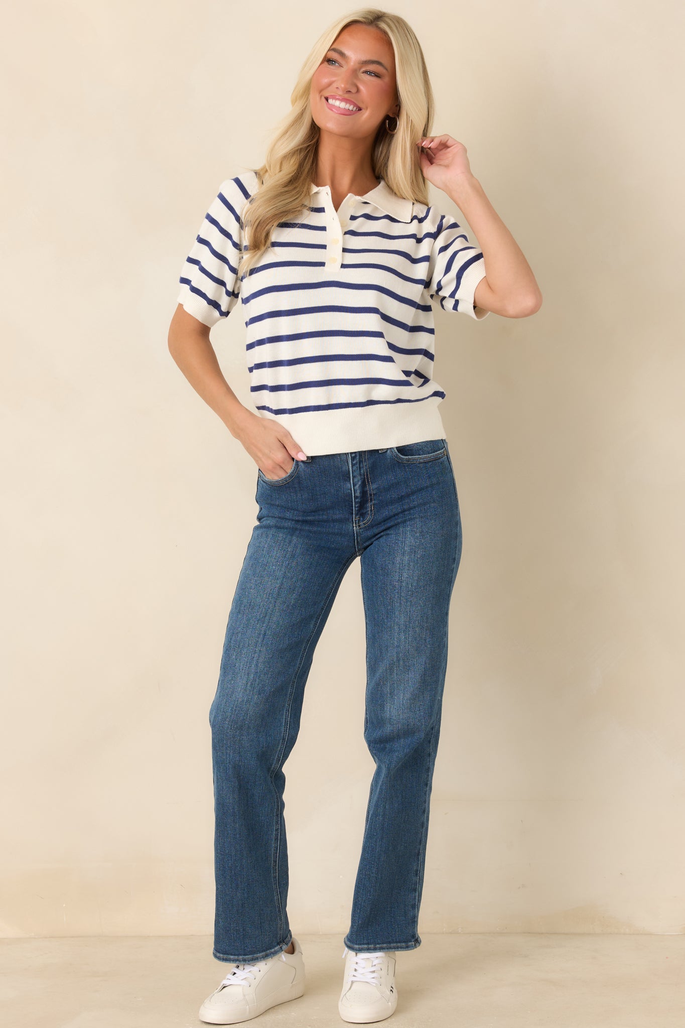 Ivory knit top featuring navy horizontal stripes, a traditional polo collar, and a functional button placket.