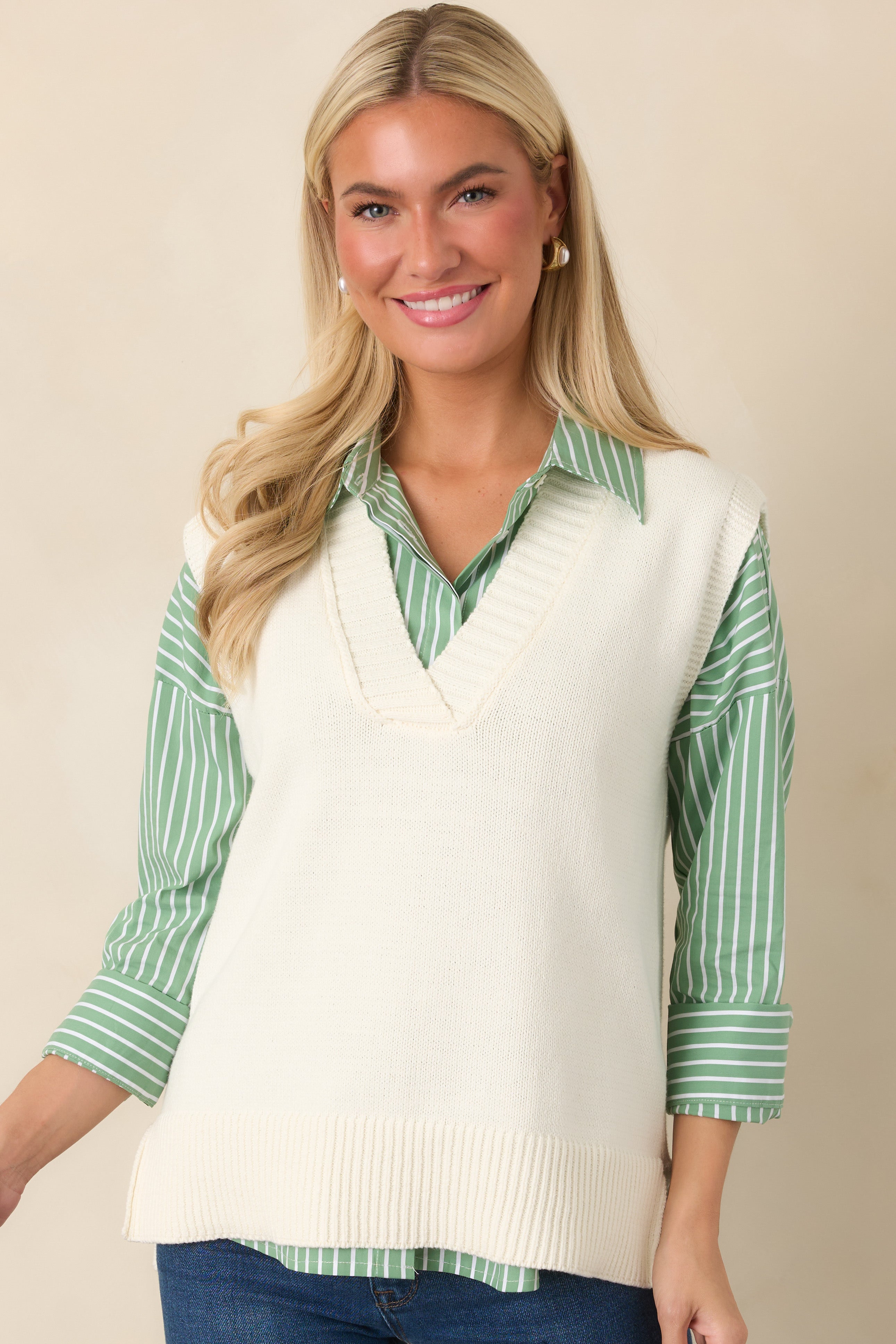 Close view highlighting the wide ribbed hem and softly textured knit construction of the ivory sweater vest.
