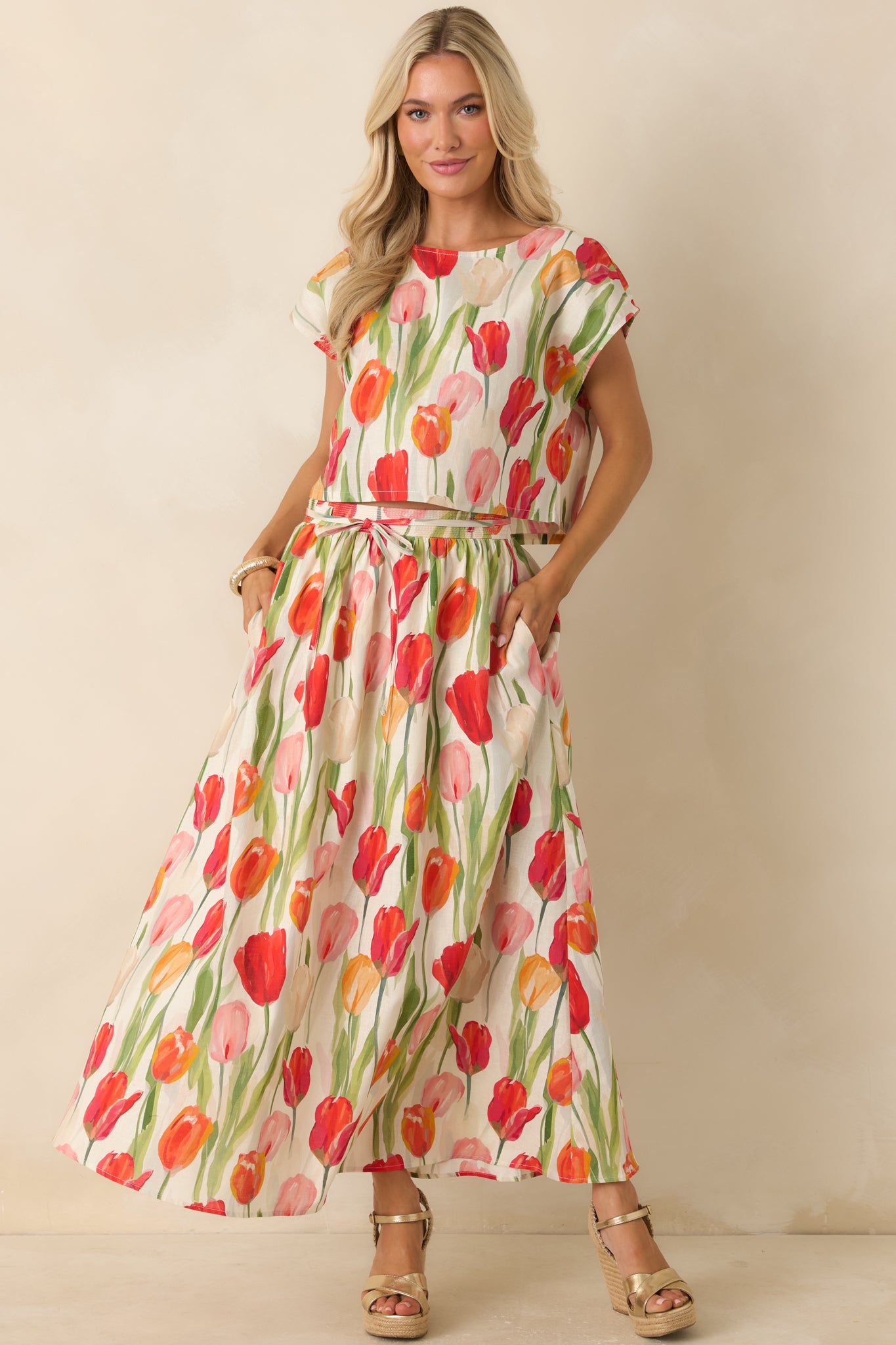 Ivory linen blend top with a vibrant tulip print, cap sleeves, and an easy cropped silhouette for a breezy look.
