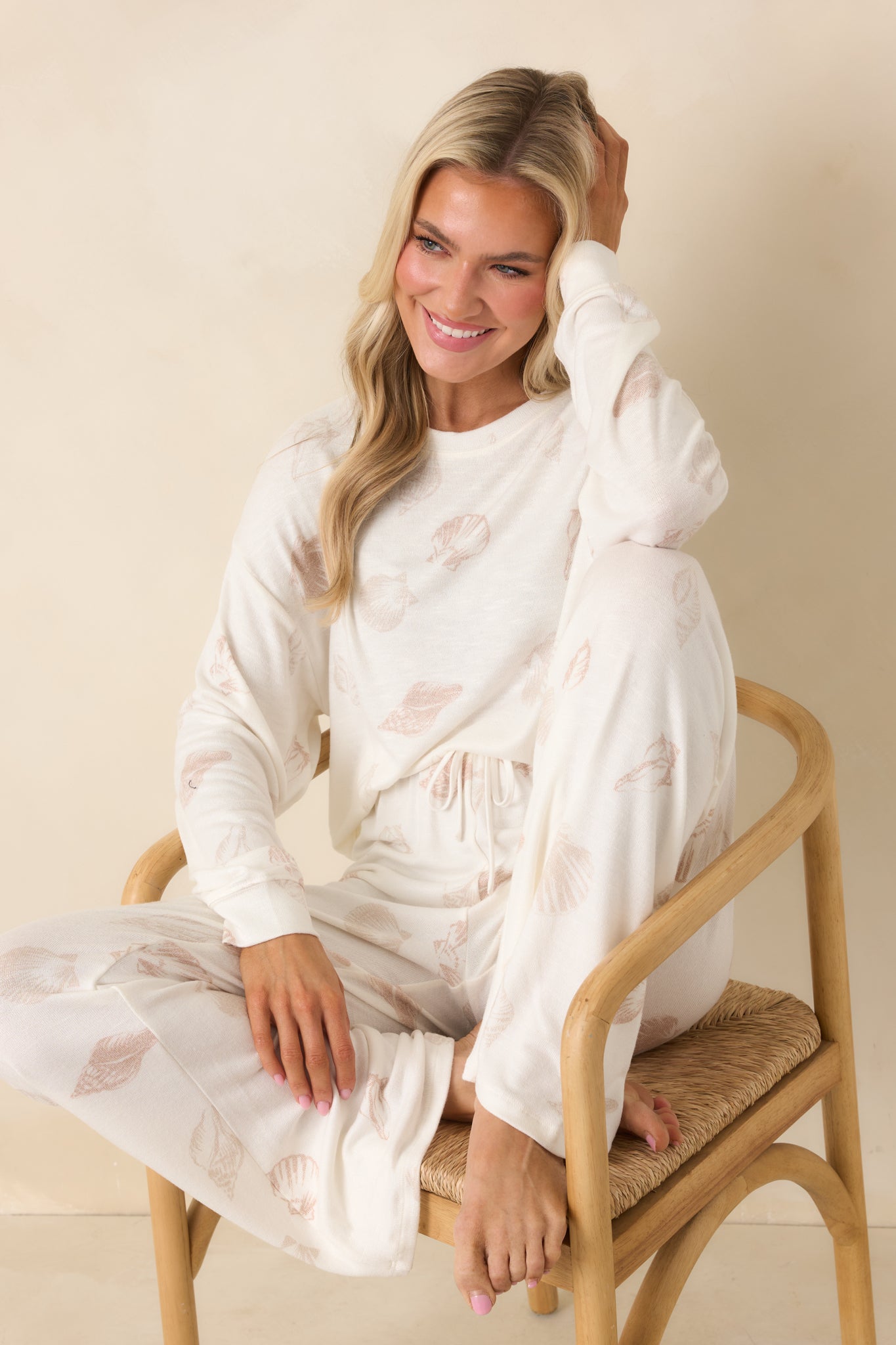 Ivory long sleeve knit top with relaxed fit, crew neckline, drop shoulders, and allover neutral shell print.