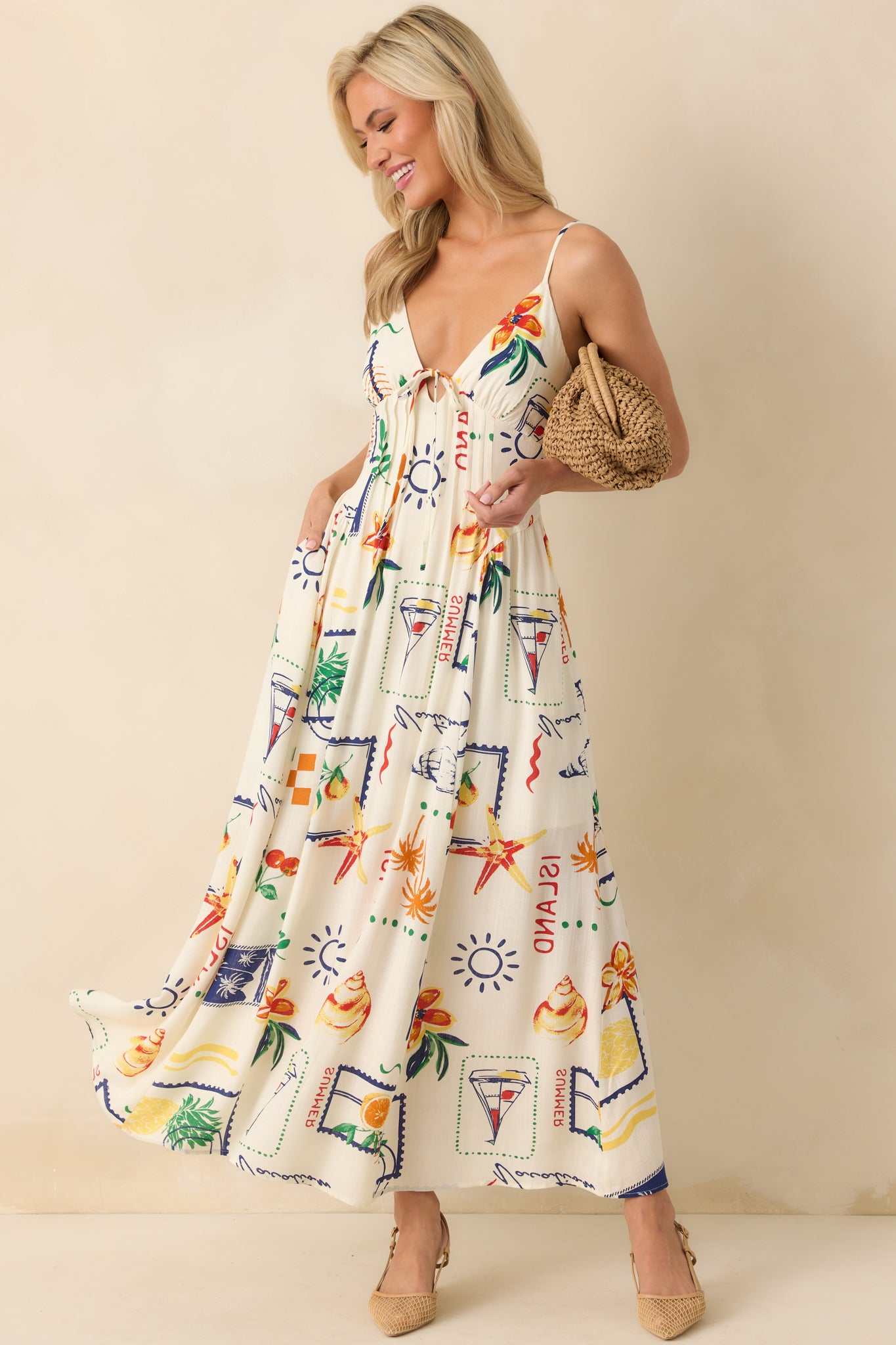 Front view of ivory maxi dress featuring a beach-inspired multicolor print and a v-neckline with a self-tie bow at the center bust.
