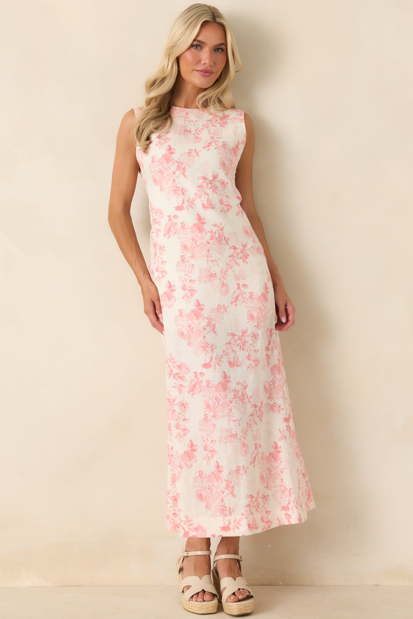 Ivory maxi dress in a linen-rayon blend featuring a soft pink floral print, round neckline, sleeveless design, and a flowing full-length silhouette.