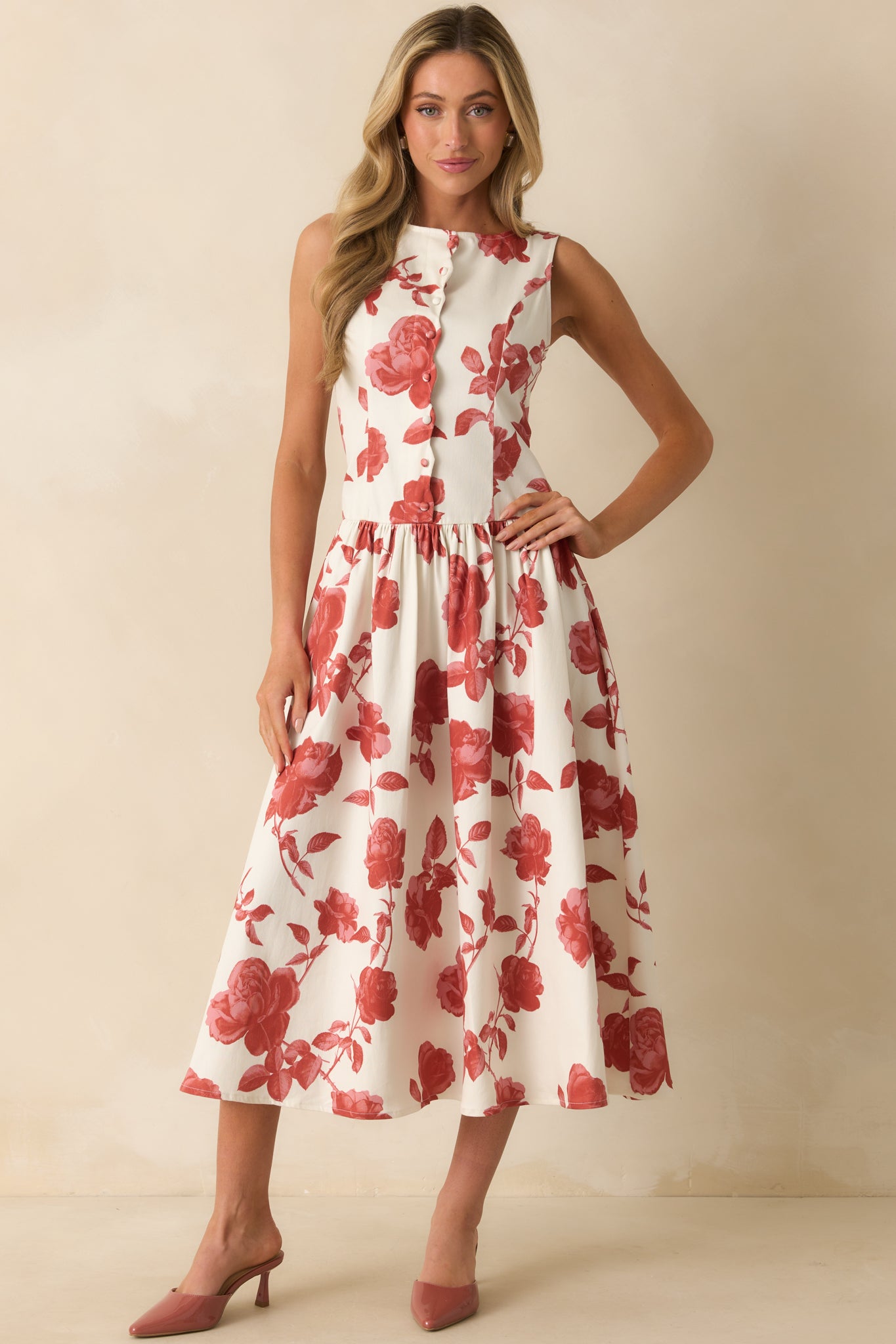 Ivory maxi dress with a sleeveless design, drop waist, and all-over brick red floral print.