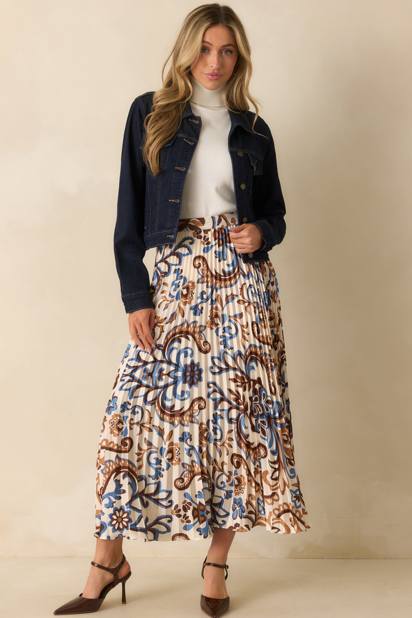 Flowing maxi skirt featuring a high rise waist and shiny ivory fabric with paisley accents.