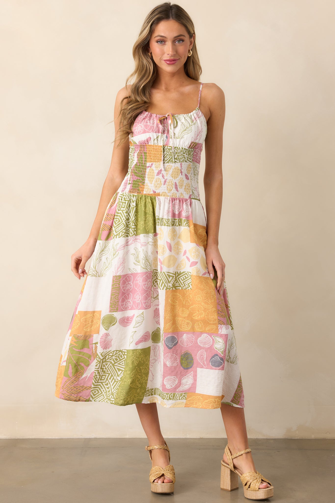 Ivory midi dress with a smocked waistband and a flowing skirt, highlighted by the colorful tropical patchwork pattern.