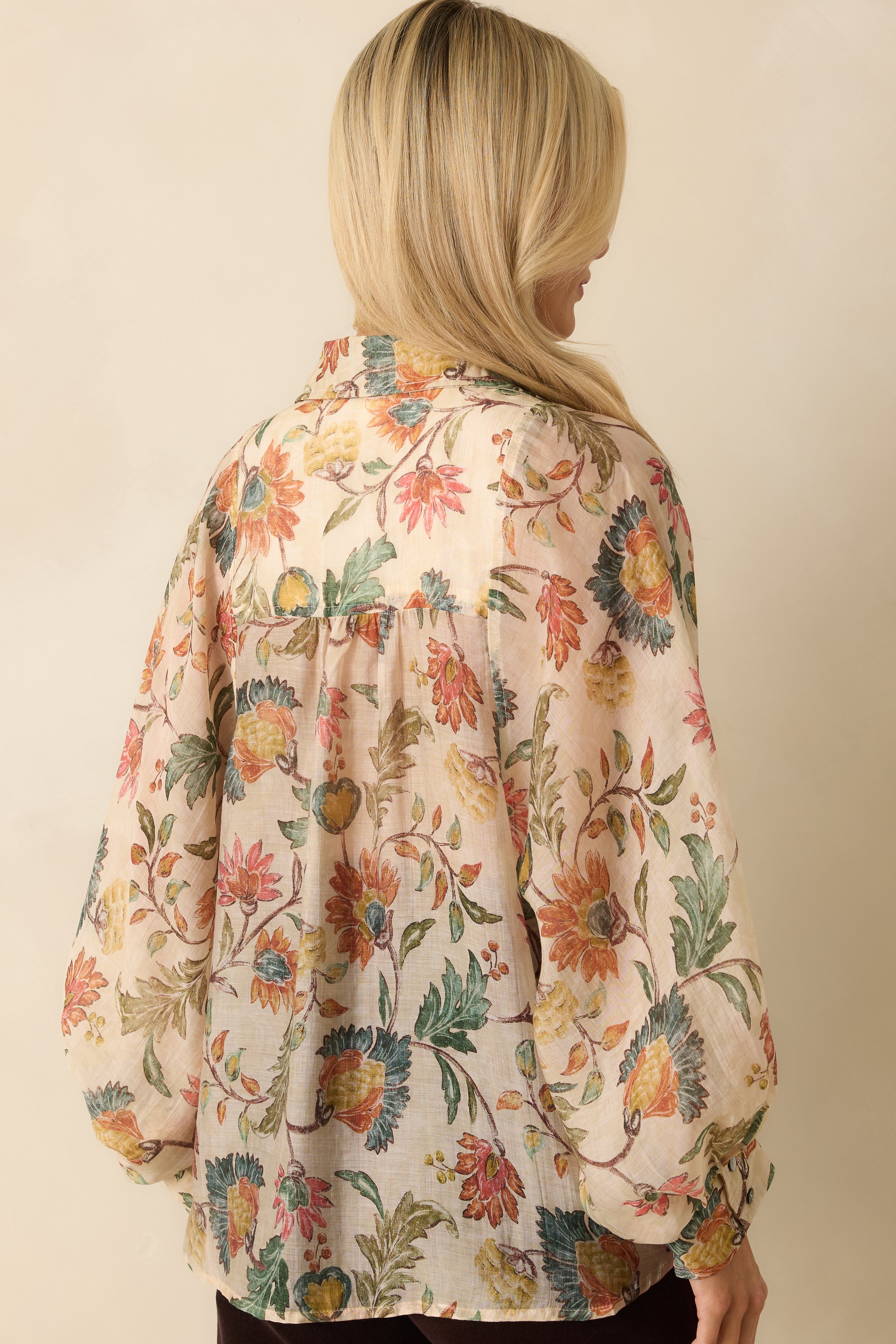 Rear view of the ivory multi floral blouse showing long peasant sleeves and relaxed fit.