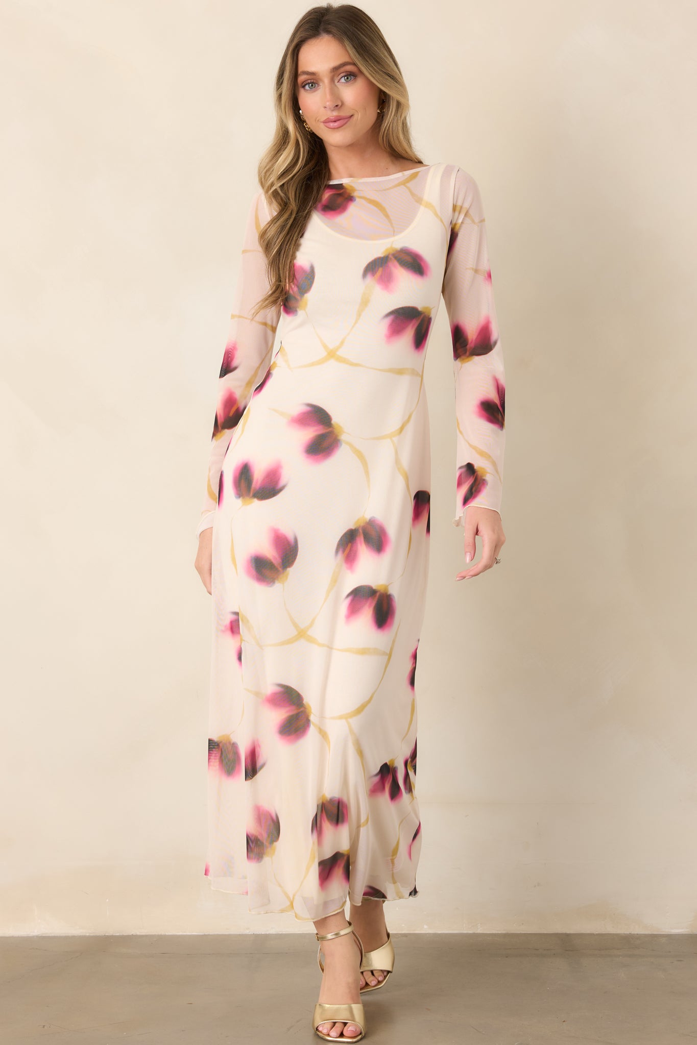 Elegant ivory mesh maxi dress showcasing a blurred multicolor floral print, streamlined bodice, full-length silhouette, and softly flared sleeve cuffs.