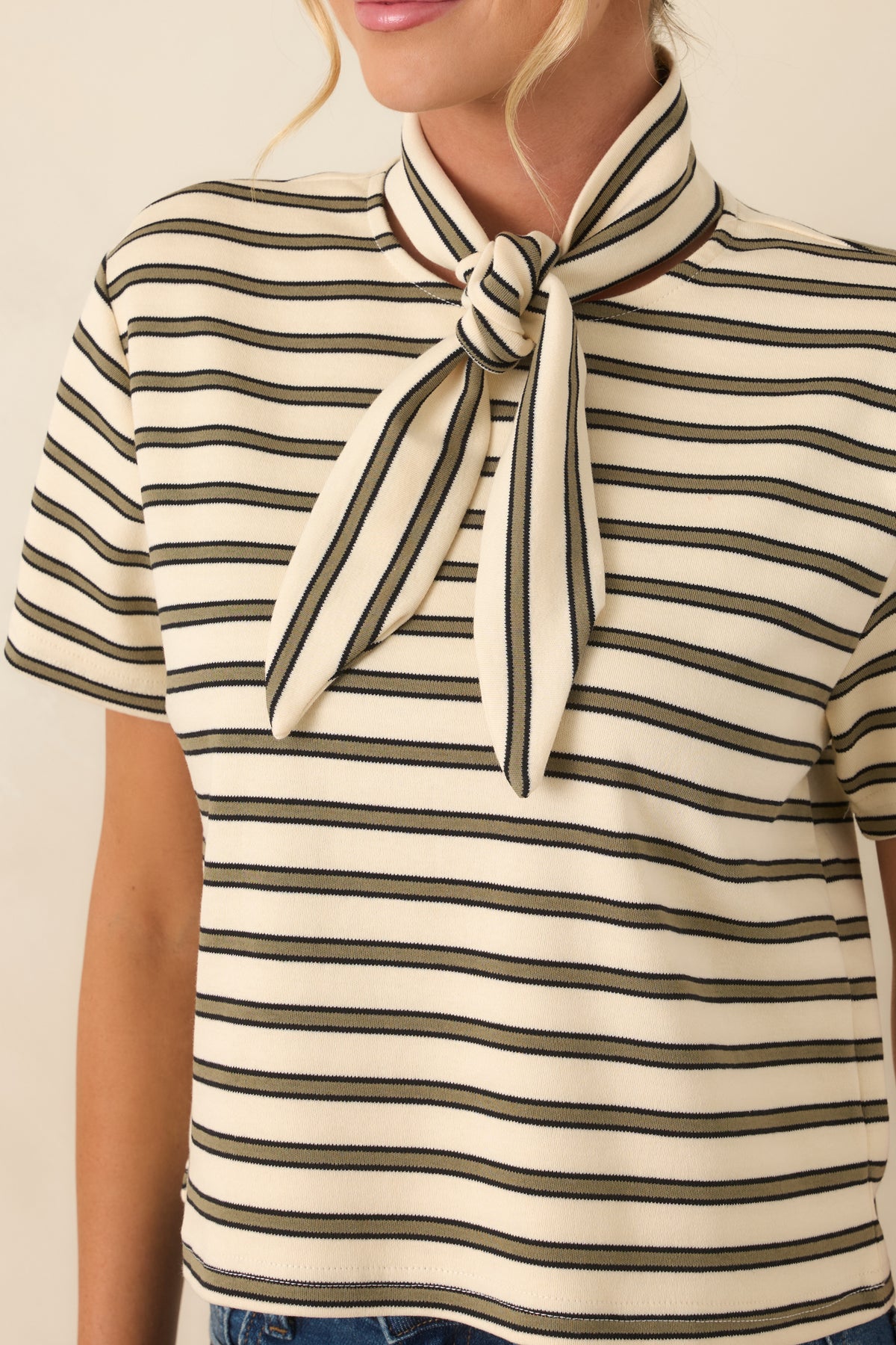Close-up of the tee showcasing the fine olive stripe pattern, ivory cotton-blend fabric, and subtle stretch texture.