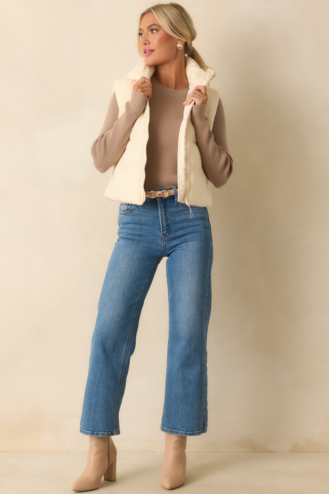 Lightly padded ivory vest featuring a functional full zip front and smooth interior lining.