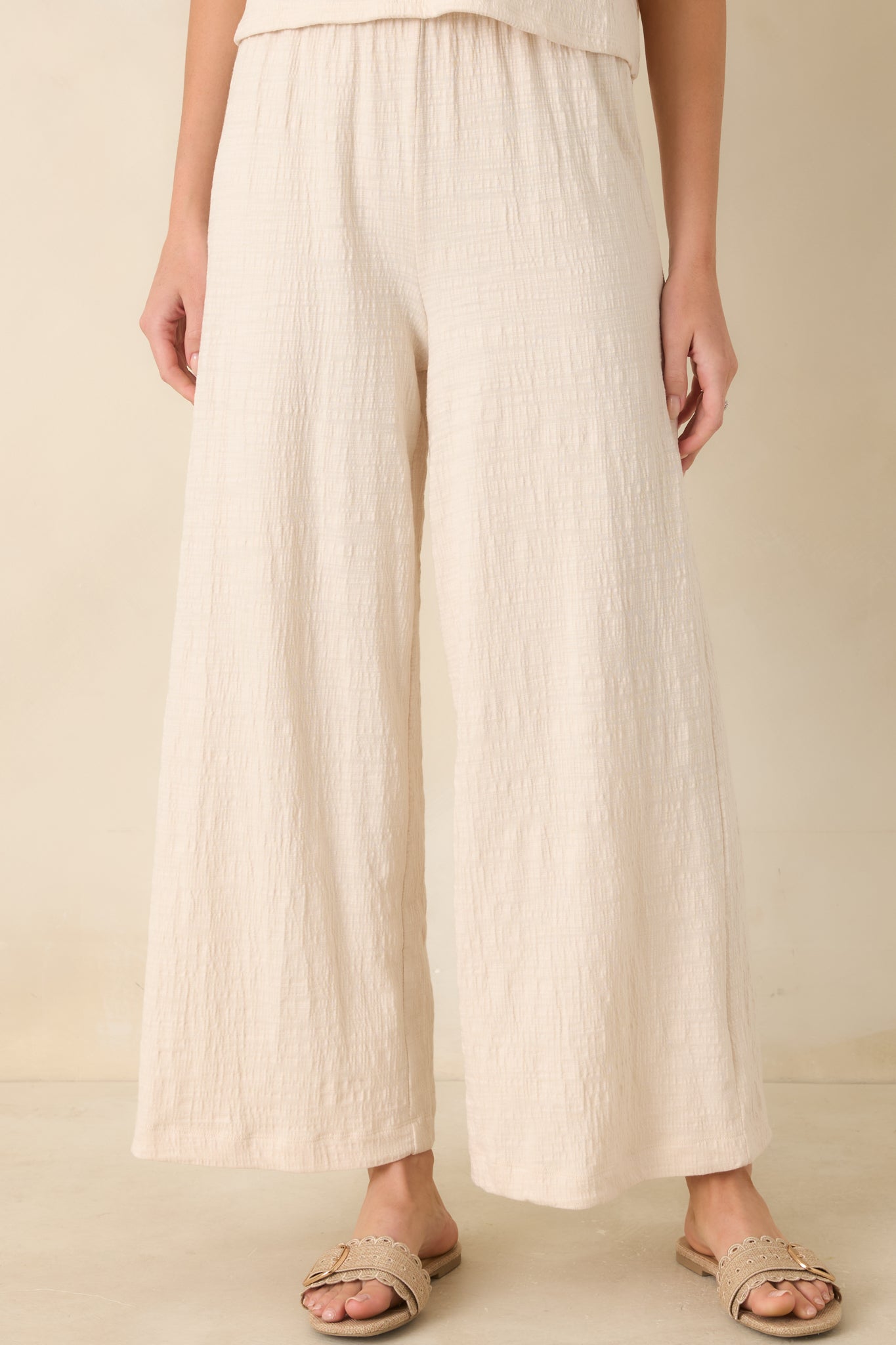 Ivory pants featuring textured slub fabric and cropped ankle-length hem.
