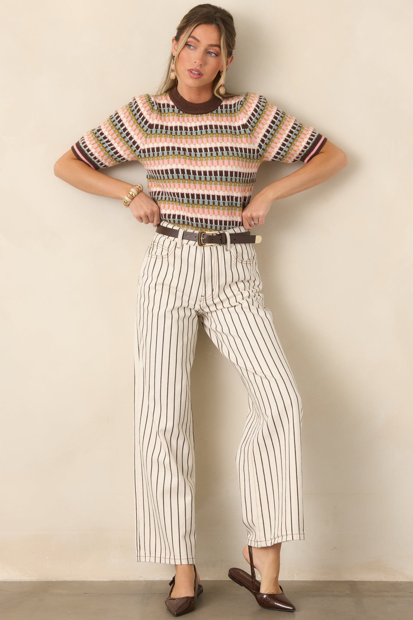 Crisp ivory pinstripe pants featuring a structured high-rise fit, classic five-pocket construction, and a tailored wide-leg silhouette extending to full length.