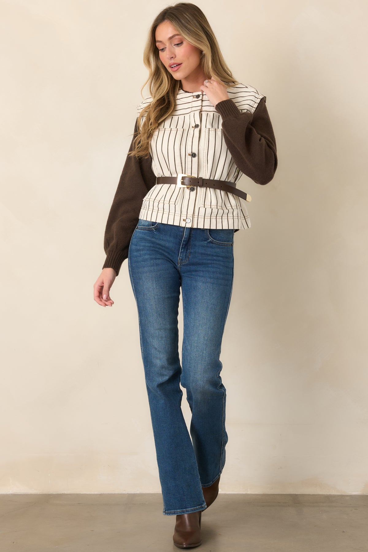 Ivory pinstripe vest showcasing its round neckline, mixed metal button detailing, oversized patch pockets, and contrasting striped yoke.