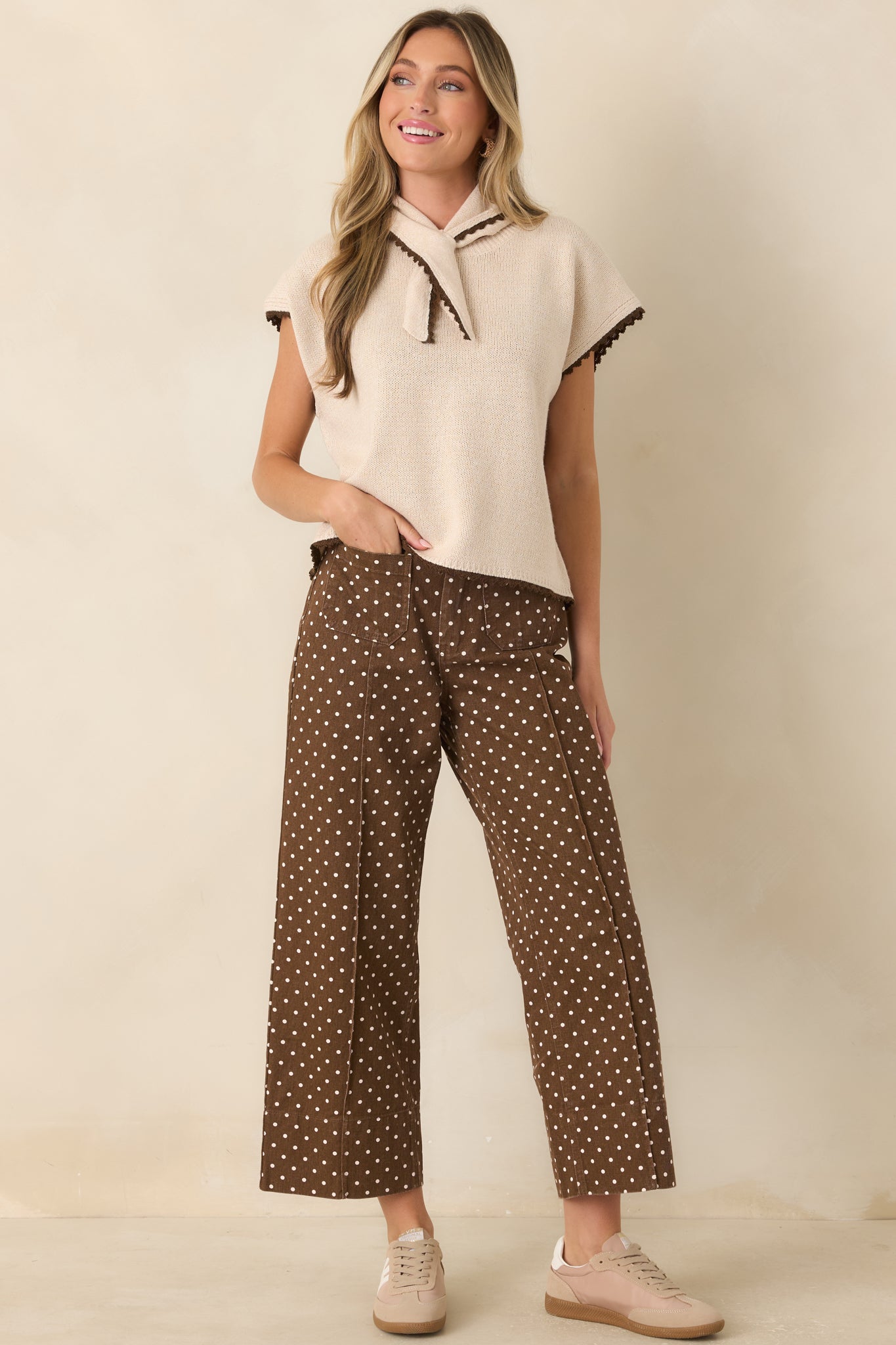 Ivory polka dot pants featuring a high-rise waist, cropped wide leg silhouette, and oversized patch pockets.