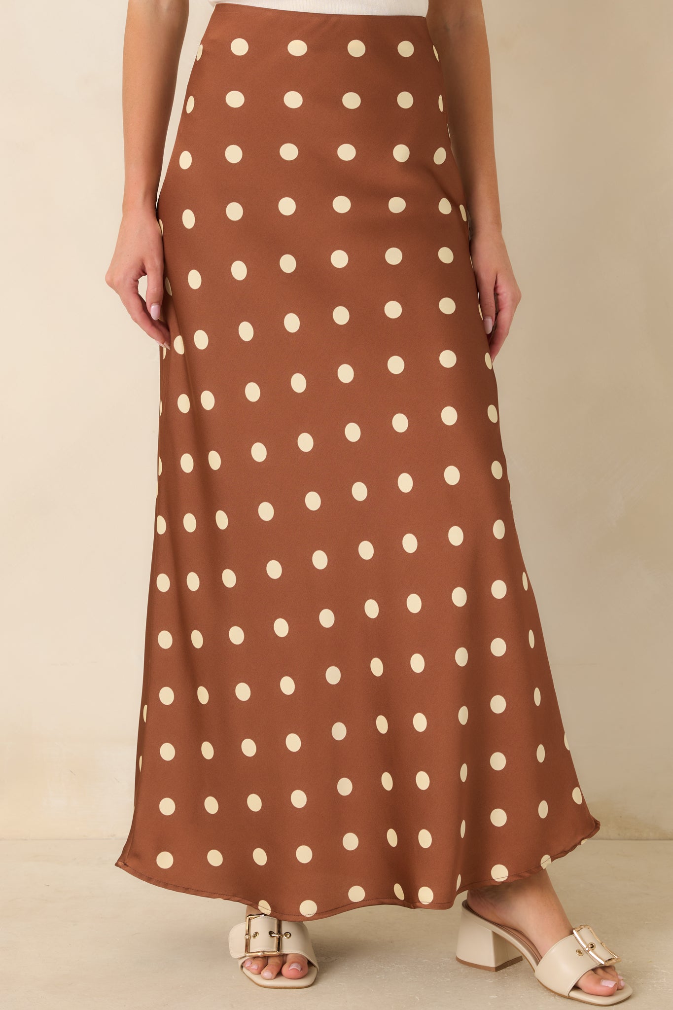 Ivory polka dot pattern adds vintage charm to the silky brown satin skirt.