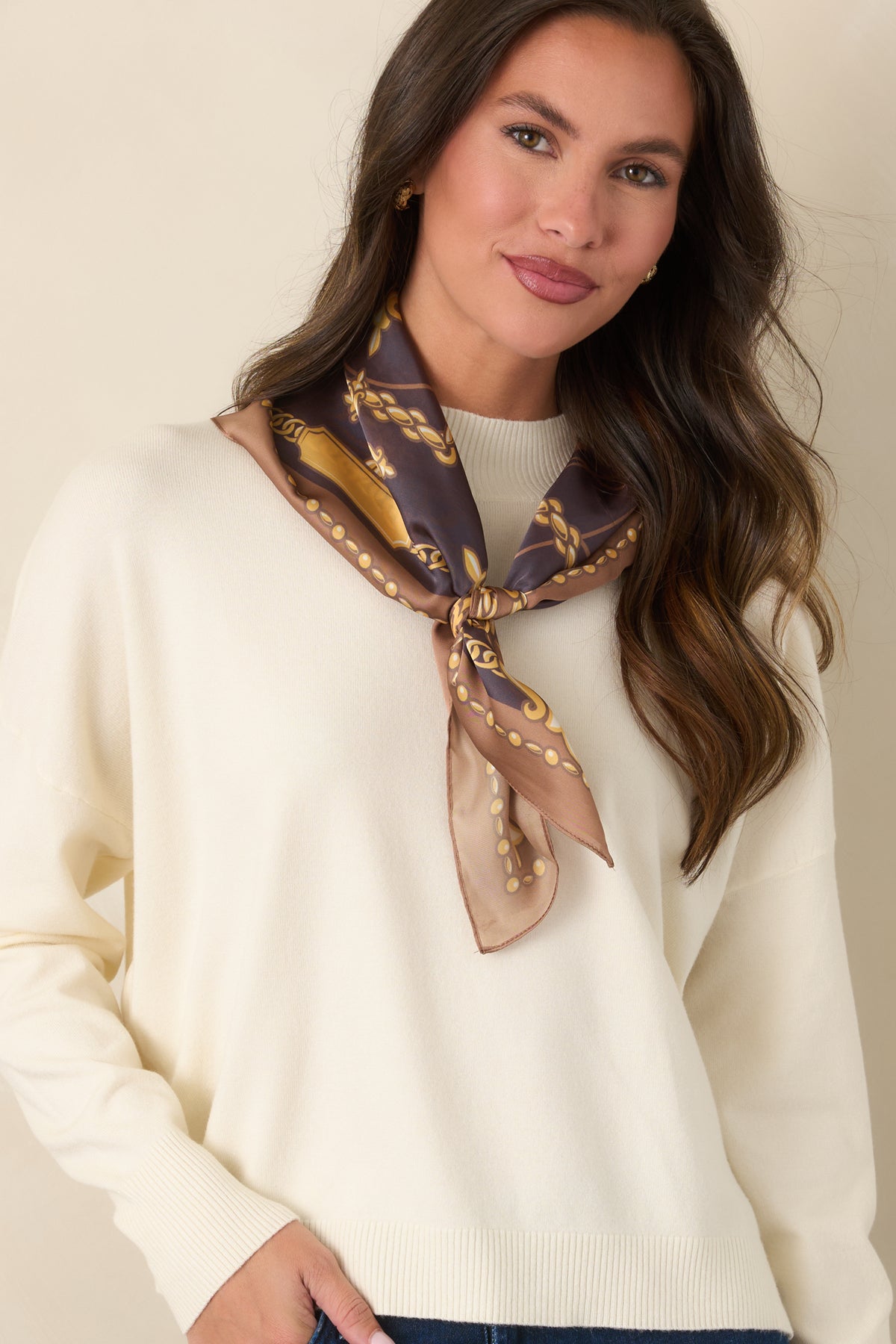 Ivory pullover featuring dropped shoulder seams and long sleeves finished with ribbed cuffs.