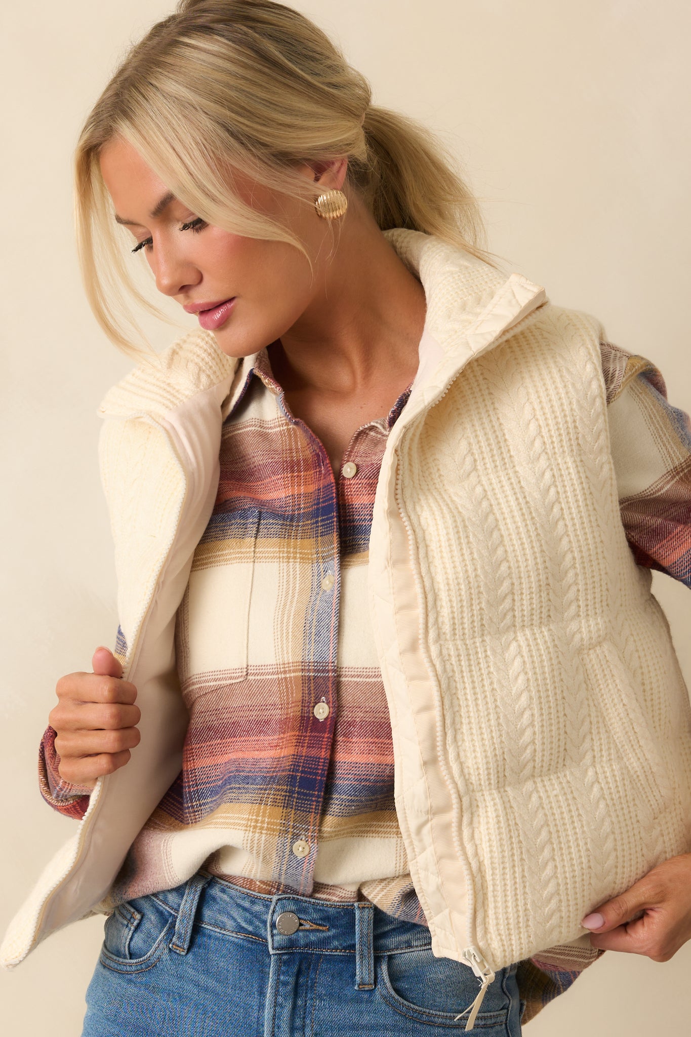 Detail showing functional front pockets on the quilted ivory vest.
