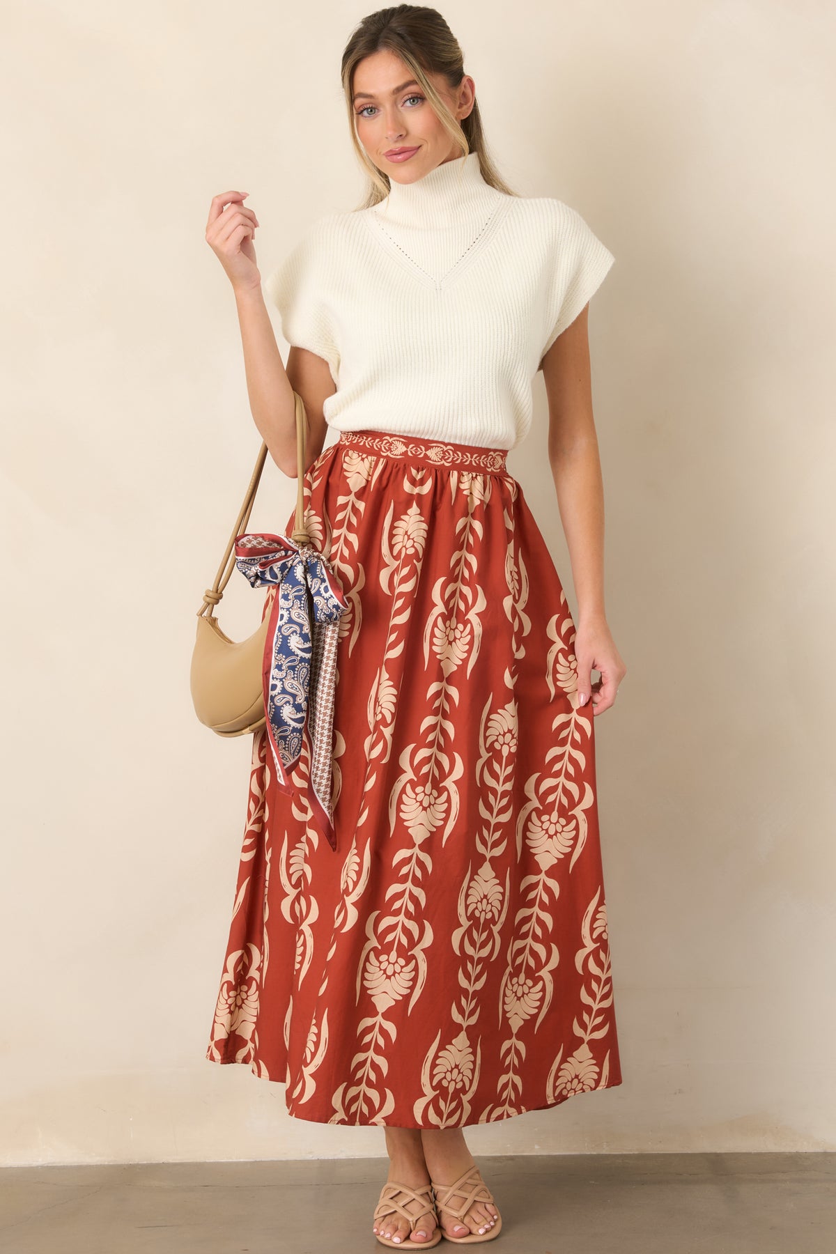Soft ivory sweater showcasing a textured ribbed construction, mock neck, short cap sleeves, and clean hemline.