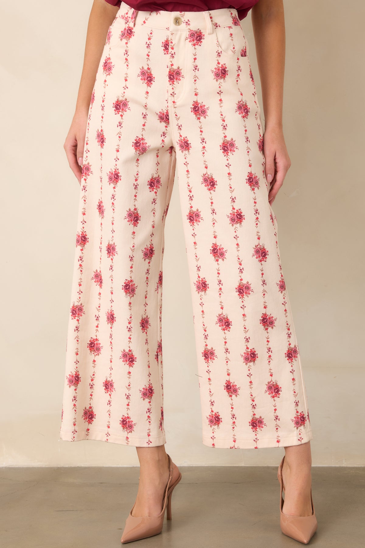 Rose-patterned pants showcasing delicate trailing vines, functional front pockets, belt loops, and smooth structured fabric.