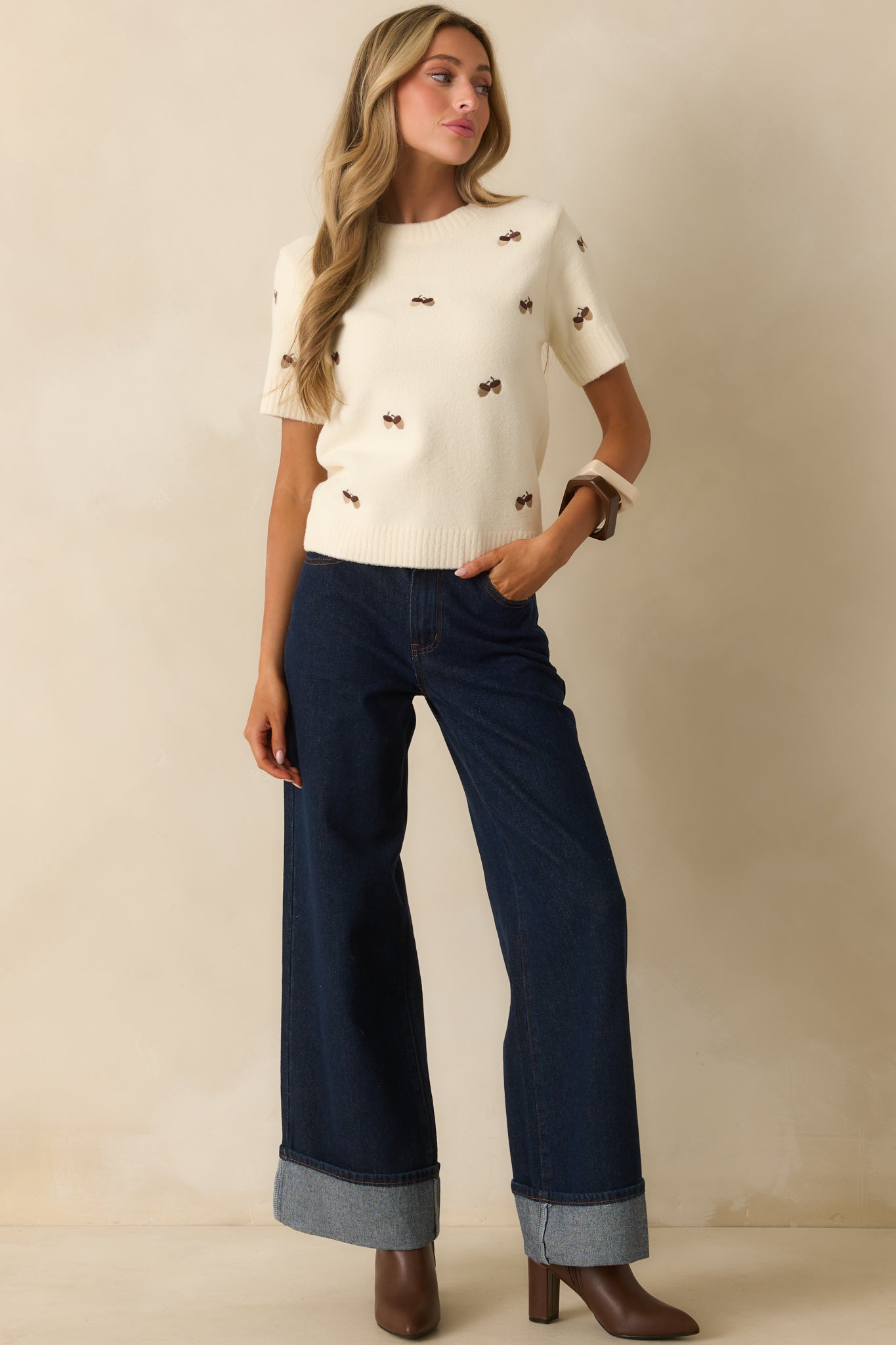 Ivory short sleeve sweater with embroidered acorn motifs and a crew neckline.