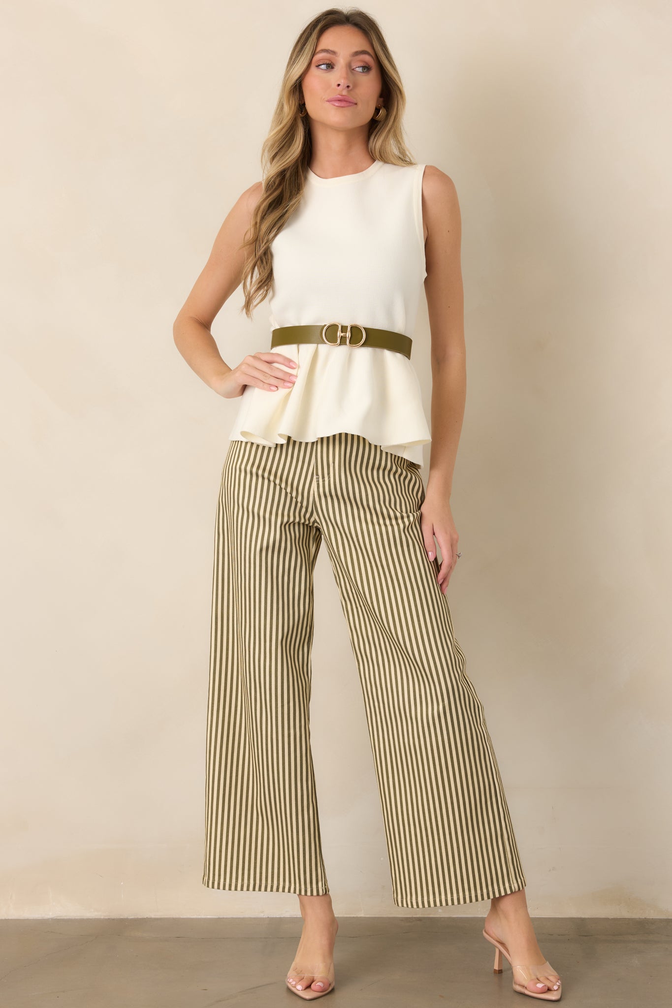 Sleek ivory sleeveless knit top showcasing a polished rounded neckline, streamlined bodice, and subtle flare below the waist.