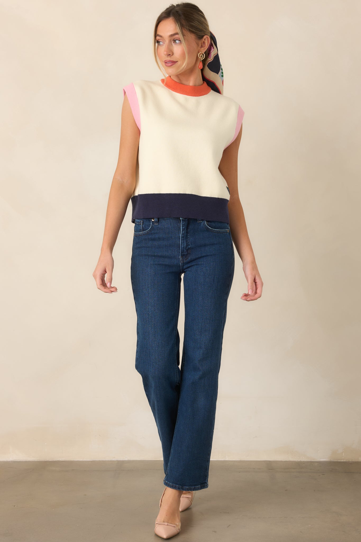 Ivory sleeveless top with a bright orange neckline, soft pink armhole trim, and deep navy ribbed hem, finished with a small heart-shaped FRNCH patch near the hem.