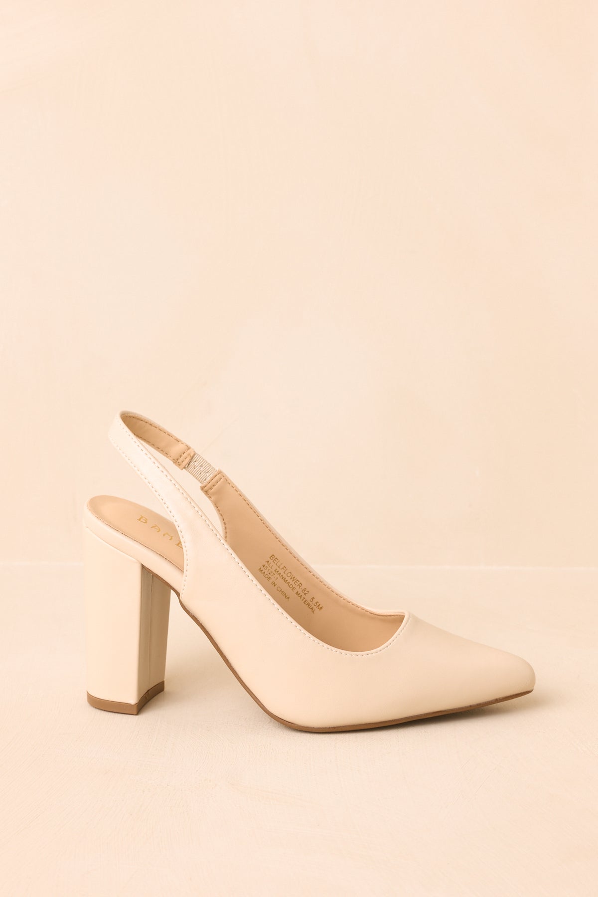 Ivory slingback heels with pointed toes, elasticized back straps, and tall block heels creating a polished silhouette.