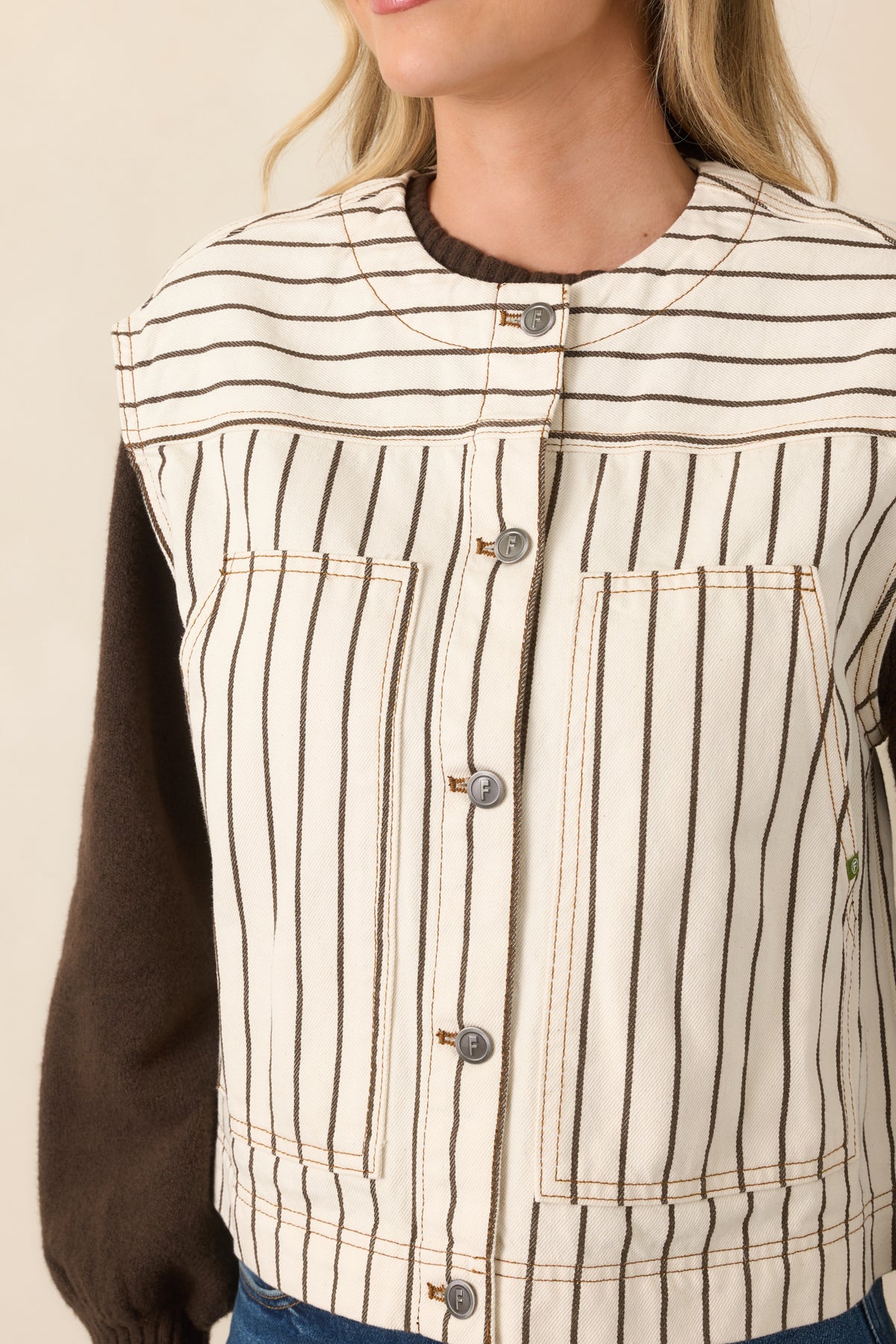 Detailed view highlighting the contrasting striped yoke, mixed metal button accents, and finely spaced brown pinstripes.