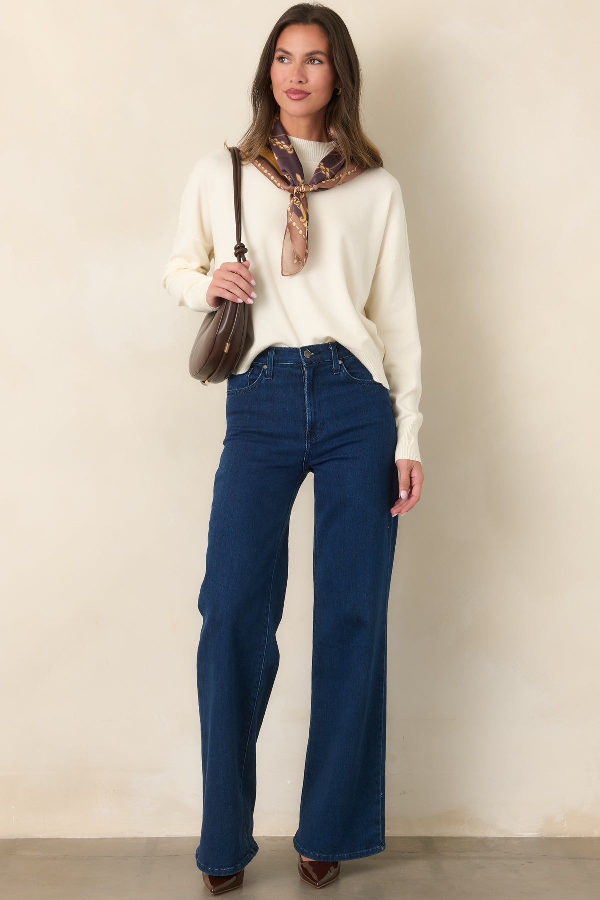 Relaxed ivory sweater featuring dropped shoulders, a ribbed neckline, and side slits along the ribbed hem.