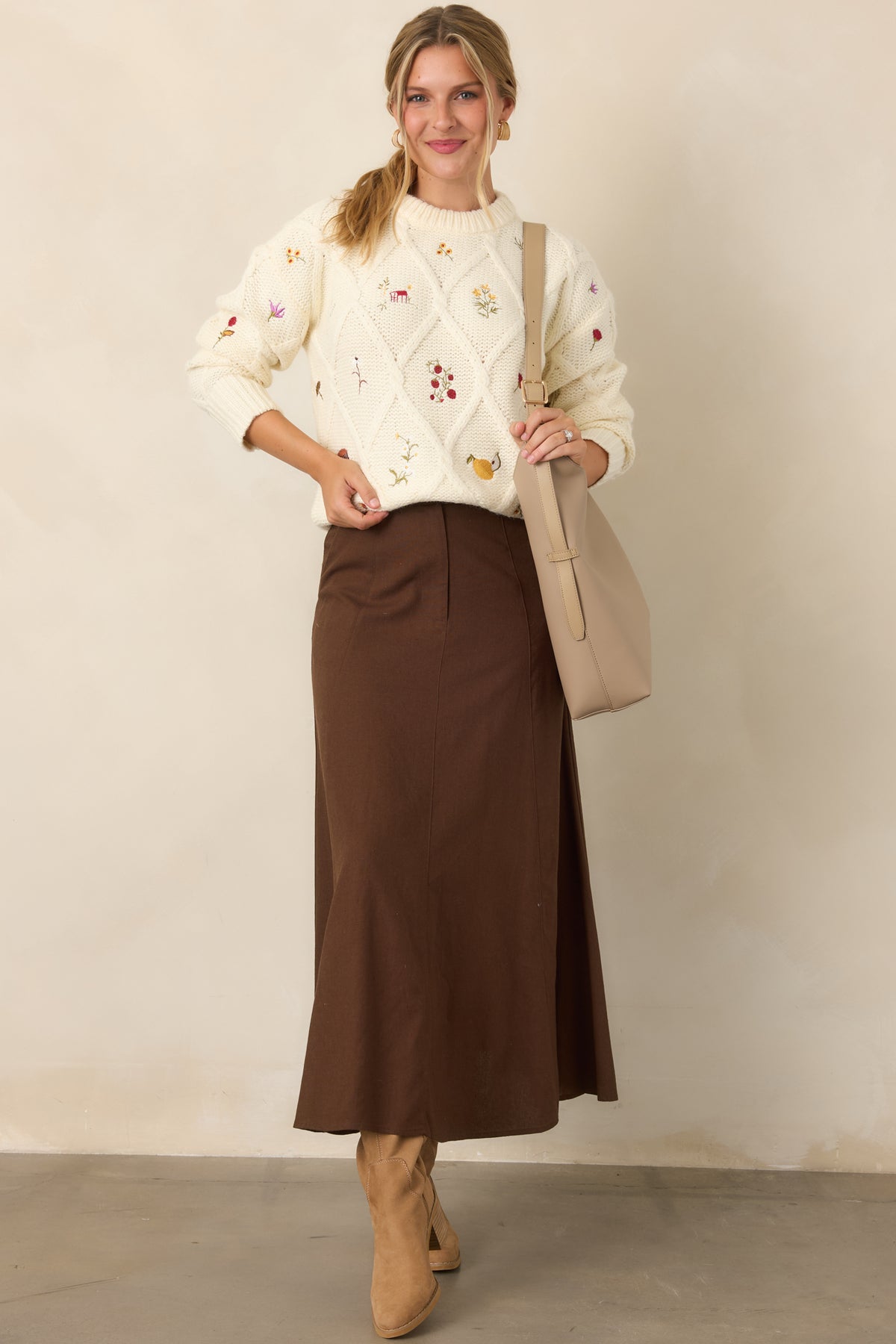 Soft ivory sweater featuring raised diamond detailing and scattered floral, berry, and fruit embroidery across the front and sleeves.
