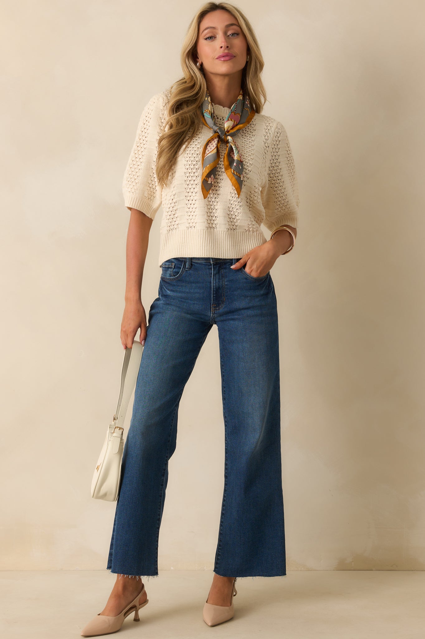 Ivory sweater with short sleeves, crew neckline, and alternating crochet and ribbed knit panels.